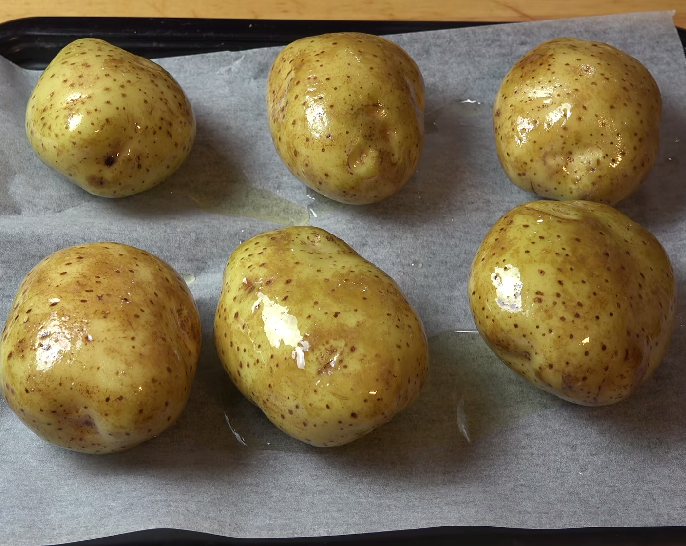 step 5 Drizzle each potato with Olive Oil (as needed). Using your hands rub the surface of each potato. Season with Salt (to taste) and Ground Black Pepper (to taste).