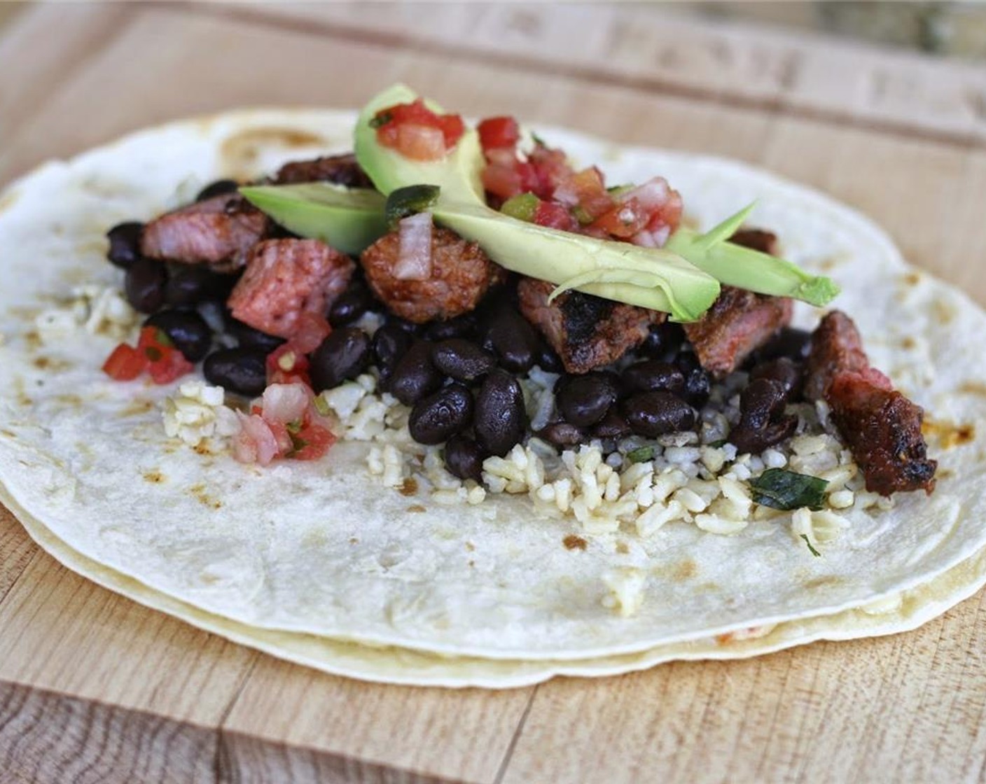 step 9 Remove to a plate or cutting board and spoon fillings, such as Black Beans (1 can) and Avocado (1) onto the center of the quesadilla.