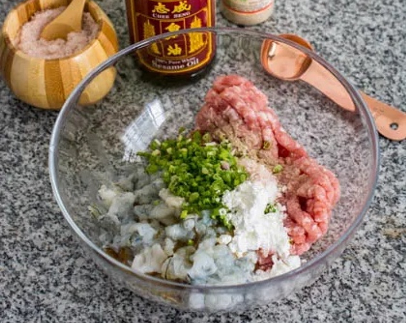 step 1 Prepare the wonton filling by combining in a bowl Ground Pork (8 oz), Shrimp (8 oz), Sesame Oil (1 Tbsp), Corn Starch (1 Tbsp), Salt (to taste), Ground White Pepper (2 dashes), and Scallions (4 Tbsp). Mix well and allow to marinate for 15 minutes.