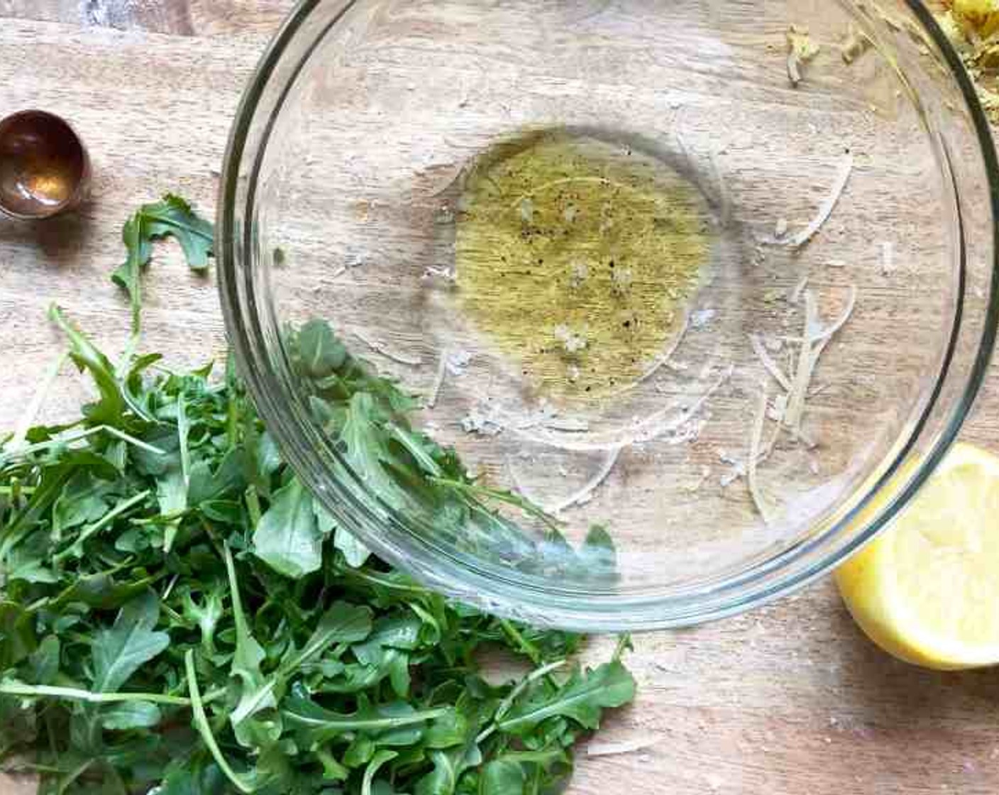 step 9 While the pizzas are baking, prepare the arugula salad. Whisk together the Extra-Virgin Olive Oil (1/2 Tbsp), 2 tsp of Lemon Juice, remaining Kosher Salt (1/8 tsp), and remaining Freshly Ground Black Pepper (1/8 tsp) in a large bowl. Stir in the Baby Arugula (4 cups) so that the leaves are evenly coated.