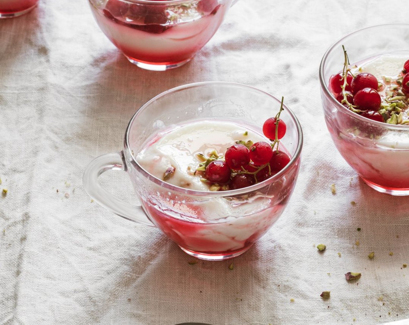 step 9 To serve, divide the rose and red currant syrup amongst the chilled milk pudding. Top each with some Pistachios (2 Tbsp) and a small bunch of Currants (1/3 cup).