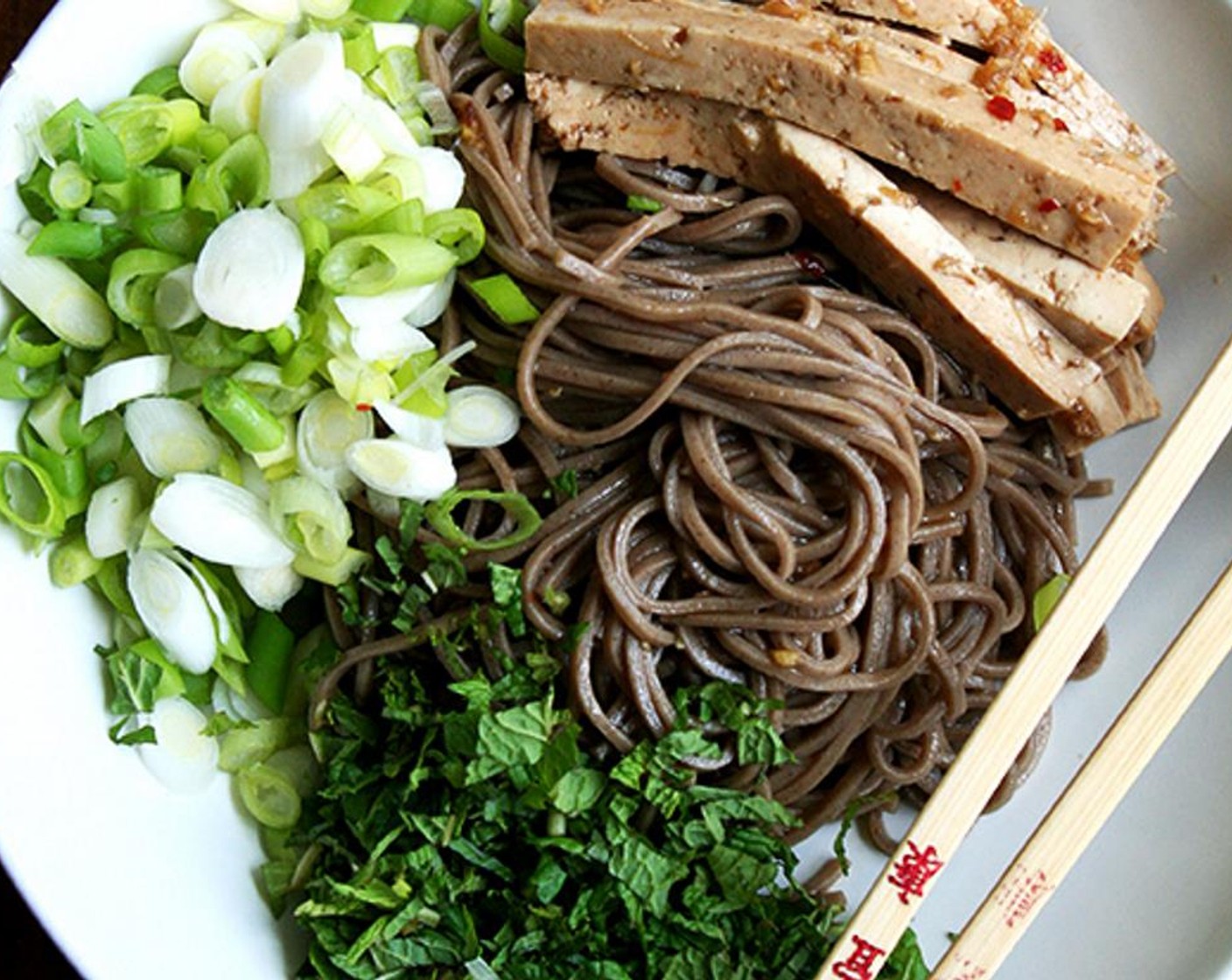 step 10 At this point, you can serve the salad however you wish. Toss the noodles with the dressing so that the noodles are nicely coated. Divide noodles among bowls. Top each bowl with scallions, mint and tofu. Serve with Sriracha on the side. Enjoy!