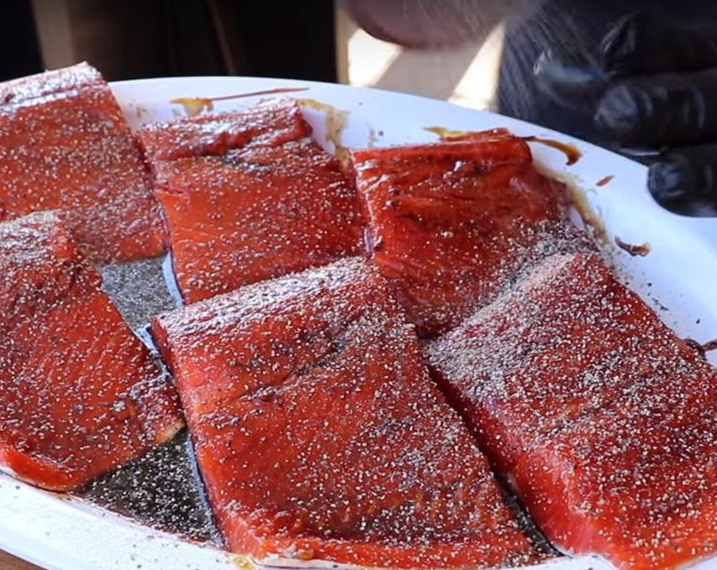 step 6 Season the salmon filets with pastrami seasoning and place directly on the cooking grate skin side down.