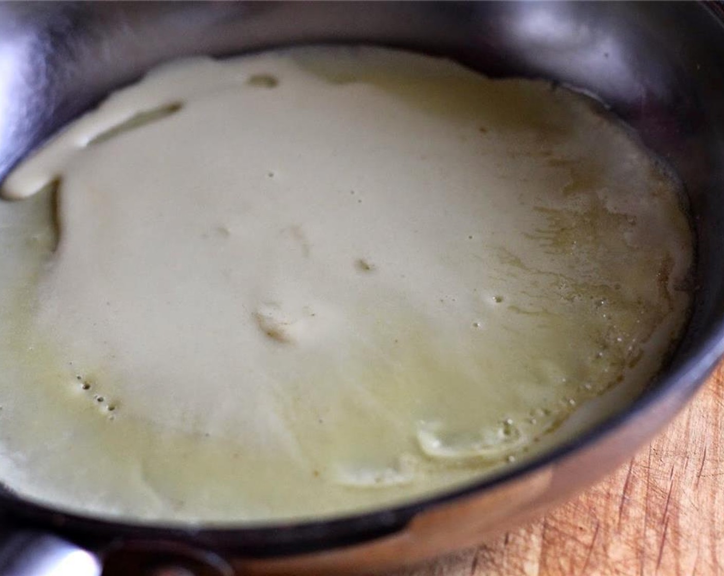 step 3 Pour a 1/4 cup of batter into the center of the pan. Rotate the pan to spread the batter into an even circle around the pan. Cook for about 1 minute, or until edges come loose and begin to lift. Flip crepe and cook 20- 30 seconds on the other side.