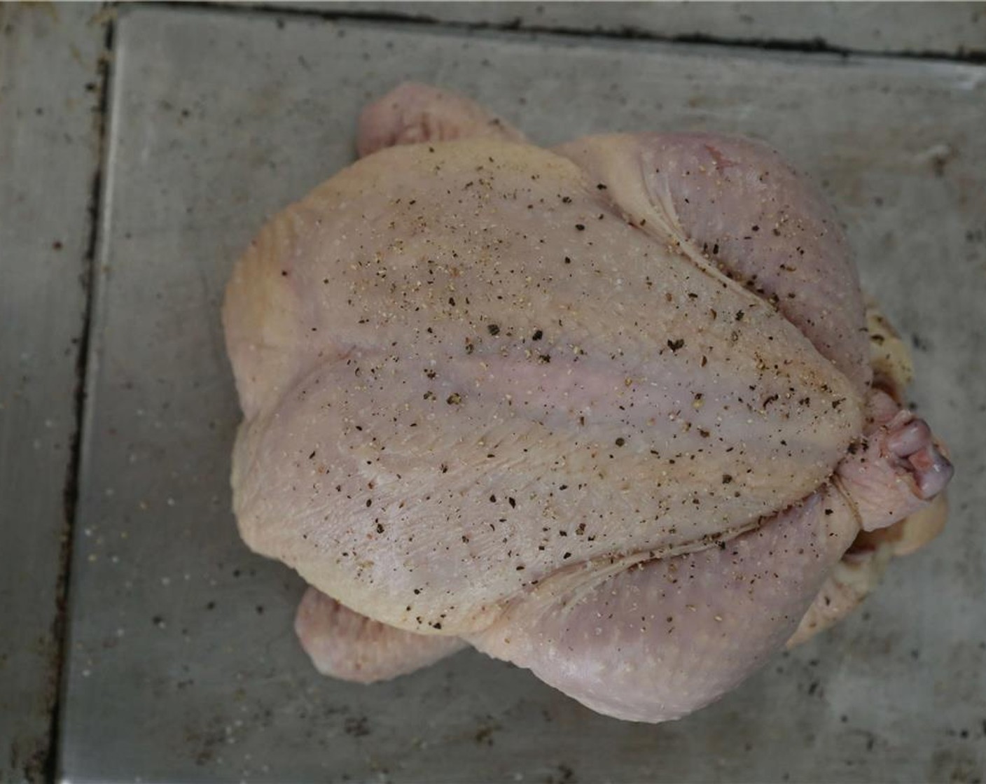 step 9 Flip the chicken back over breast-side up. Pull the wing tips back, so the chicken is ready to tan. Season with Salt (to taste) and Ground Black Pepper (to taste) on both sides. Place on a roasting pan, and roast in a 450 degrees F (230 degrees C) oven for 50 to 60 minutes, or until a thermometer inserted into the thigh reads 165 degrees F.