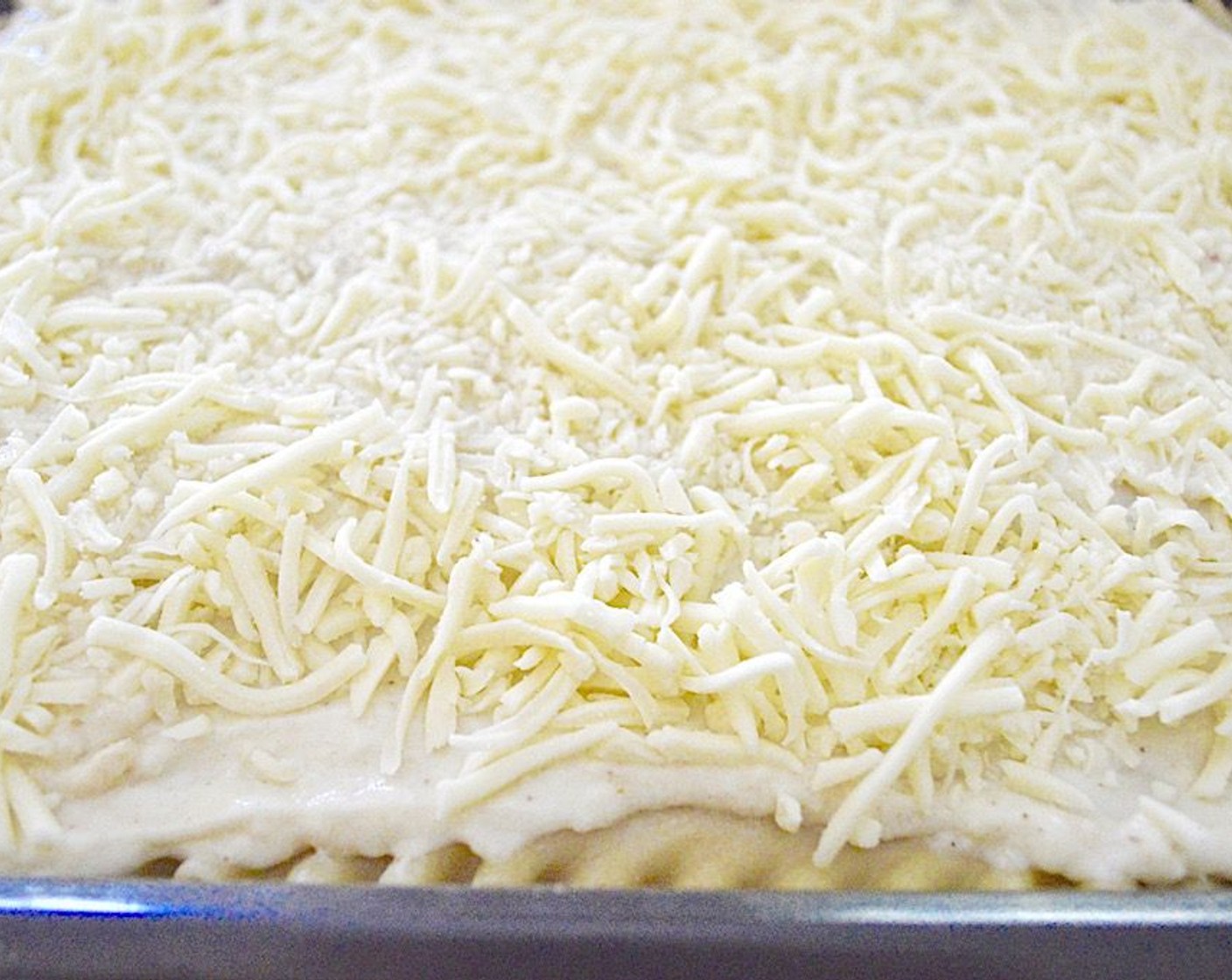 step 12 Repeat this layering twice more to have 3 layers total. Then lay out the final 4 lasagna noodles on top, followed by the remaining bechamel in a thick layer and the rest of the mozzarella.