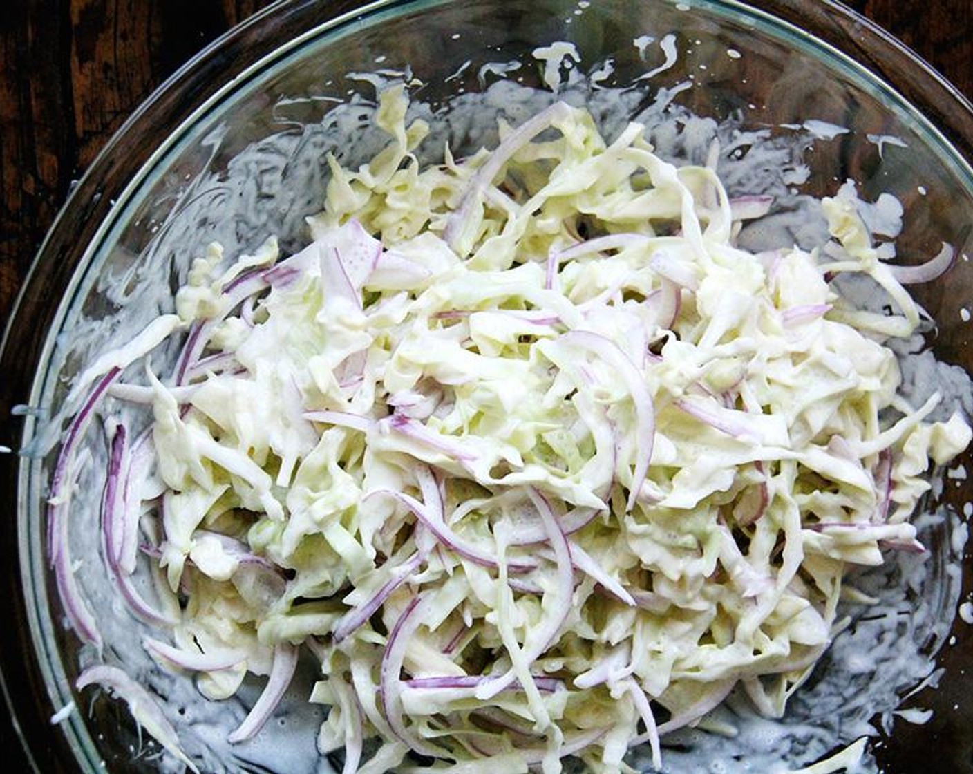 step 2 In a large bowl, toss together the Green Cabbage (1 head) and Red Onion (1). Add the dressing and toss to coat. Taste. Adjust with more salt if necessary.