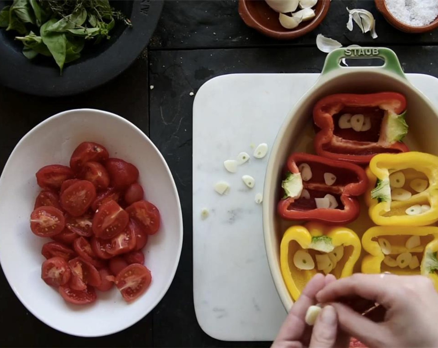 step 3 Lay the pepper halves in a lightly oiled roasting tray. Peel Garlic (3 cloves), slice them thinly, and divide the slices equally among the halved peppers.