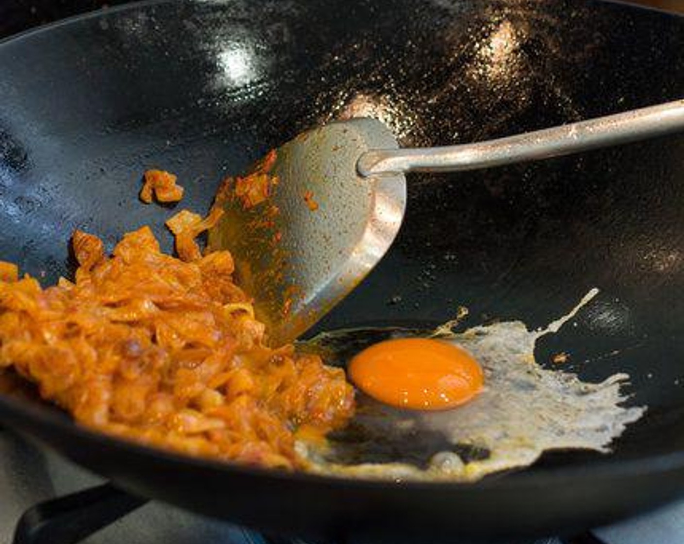 step 5 Push the noodles to the side of the wok, then crack the Egg (1) in the center of the wok. Allow the egg to cook for about 10 - 20 seconds, then stir it in to the noodles.