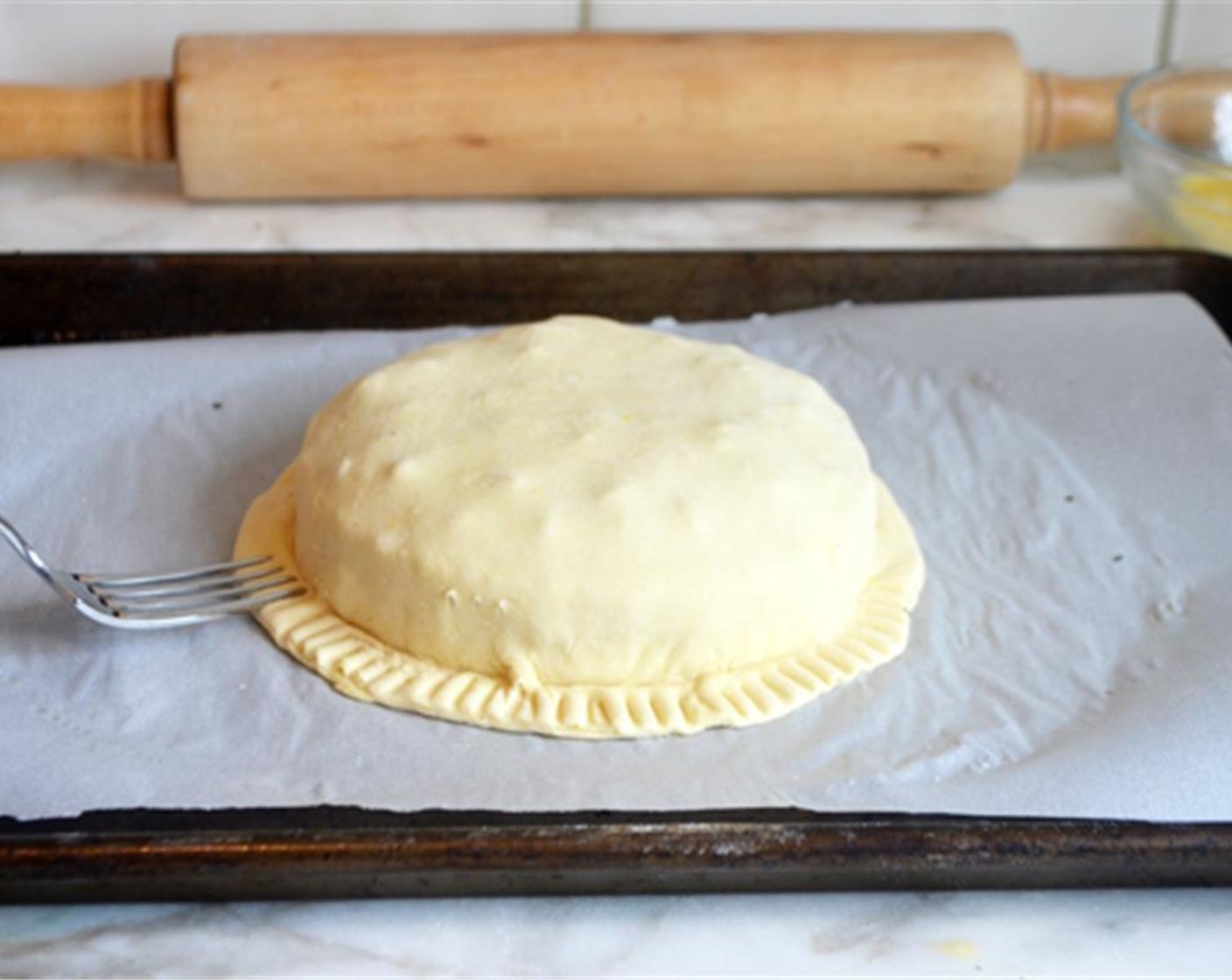 step 7 Use a fork to firmly crimp the edges and seal in the cheese. Brush the top of the pastry with the egg wash.
