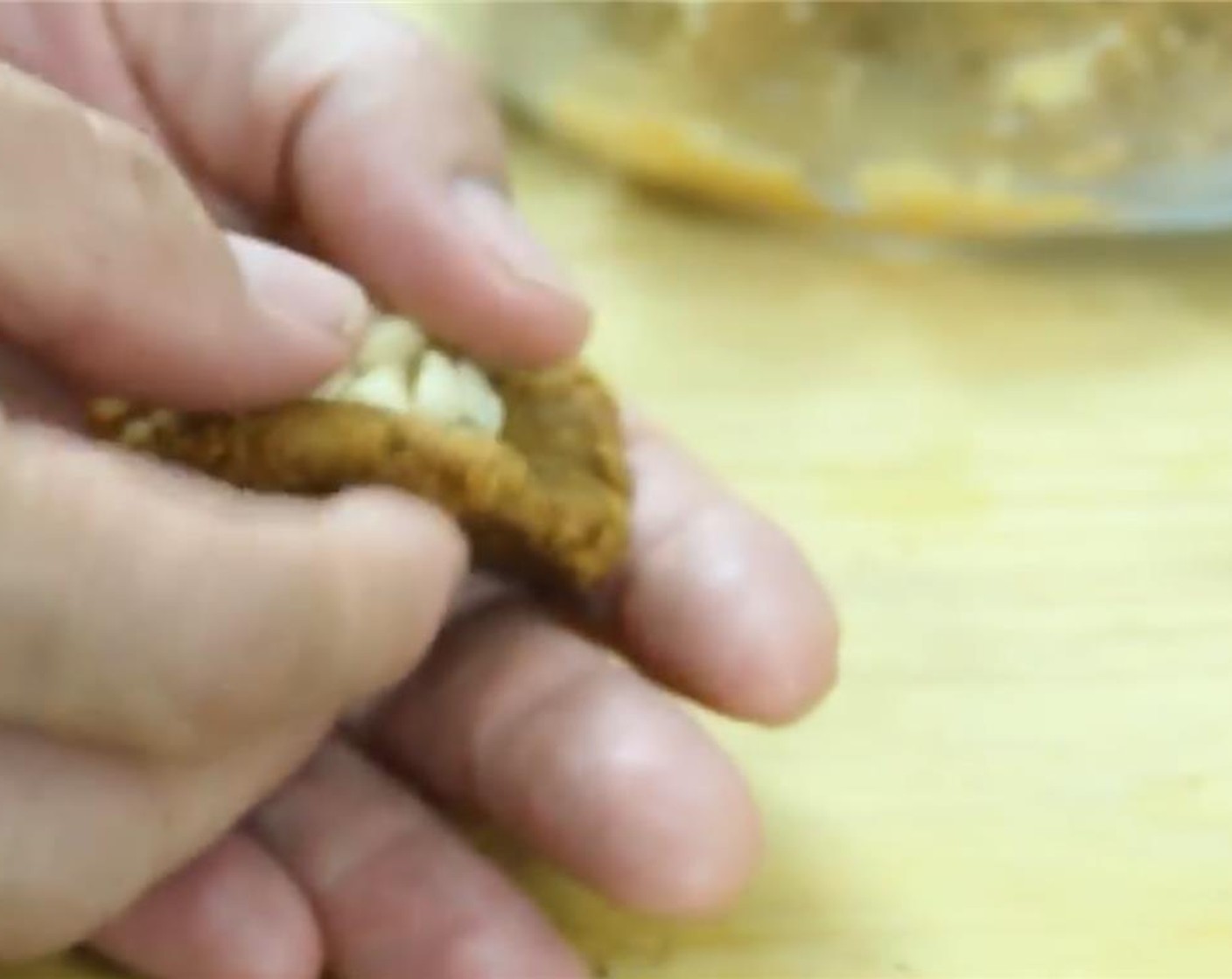 step 3 Scoop up a heaping tablespoon of the mixture into the palm of your hand and roll it into a ball. Flatten the ball into a disk shape and place about 12 White Chocolate Chips (1/4 cup) for each one in the center.