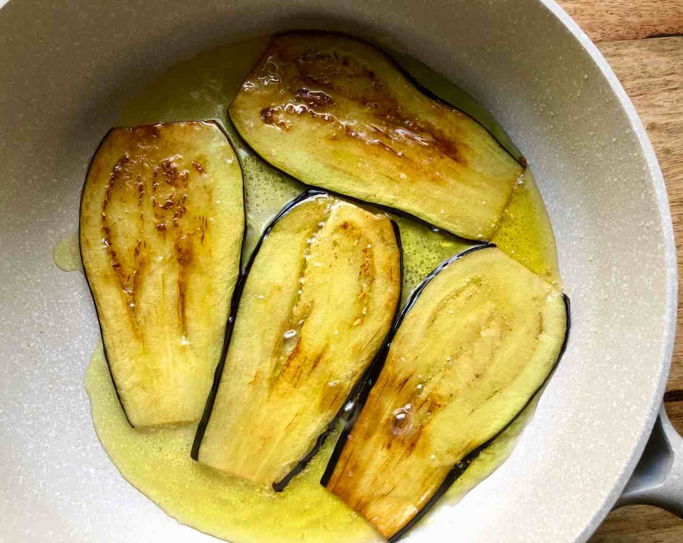 step 5 When done, place them in a single layer on sheets of parchment paper to prevent sticking. Heat Olive Oil (1/2 cup) in a large nonstick skillet over medium-high heat. Add 4-5 eggplant slices and cook until golden brown and crisp, 1 to 2 minutes per side.