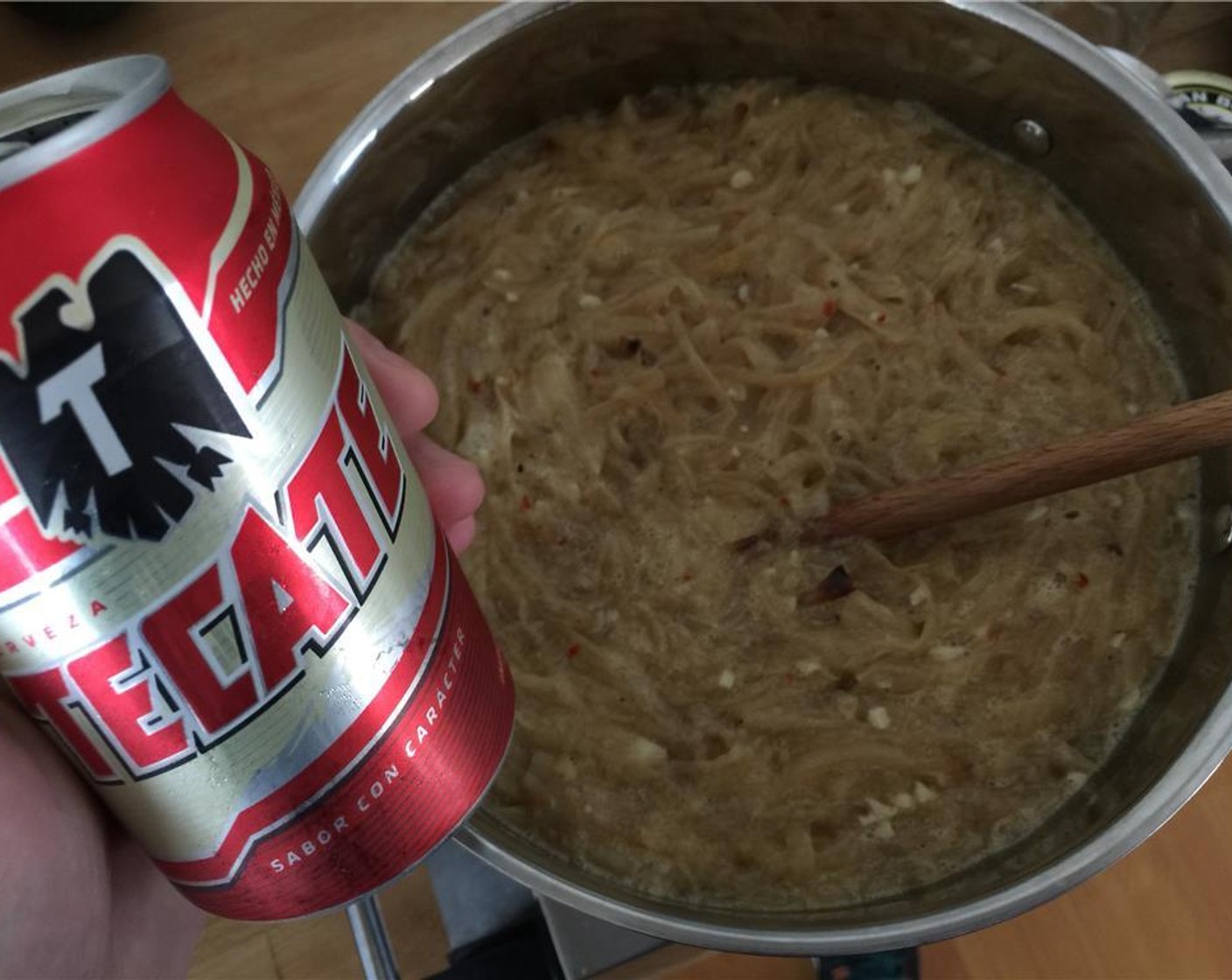 step 9 Transfer the onions to a medium to large-sized pot. Crack open that Tecate (1 can) and start pouring. Bring to a boil. Stir from time to time to make sure the bottom of the pan doesn't scorch.