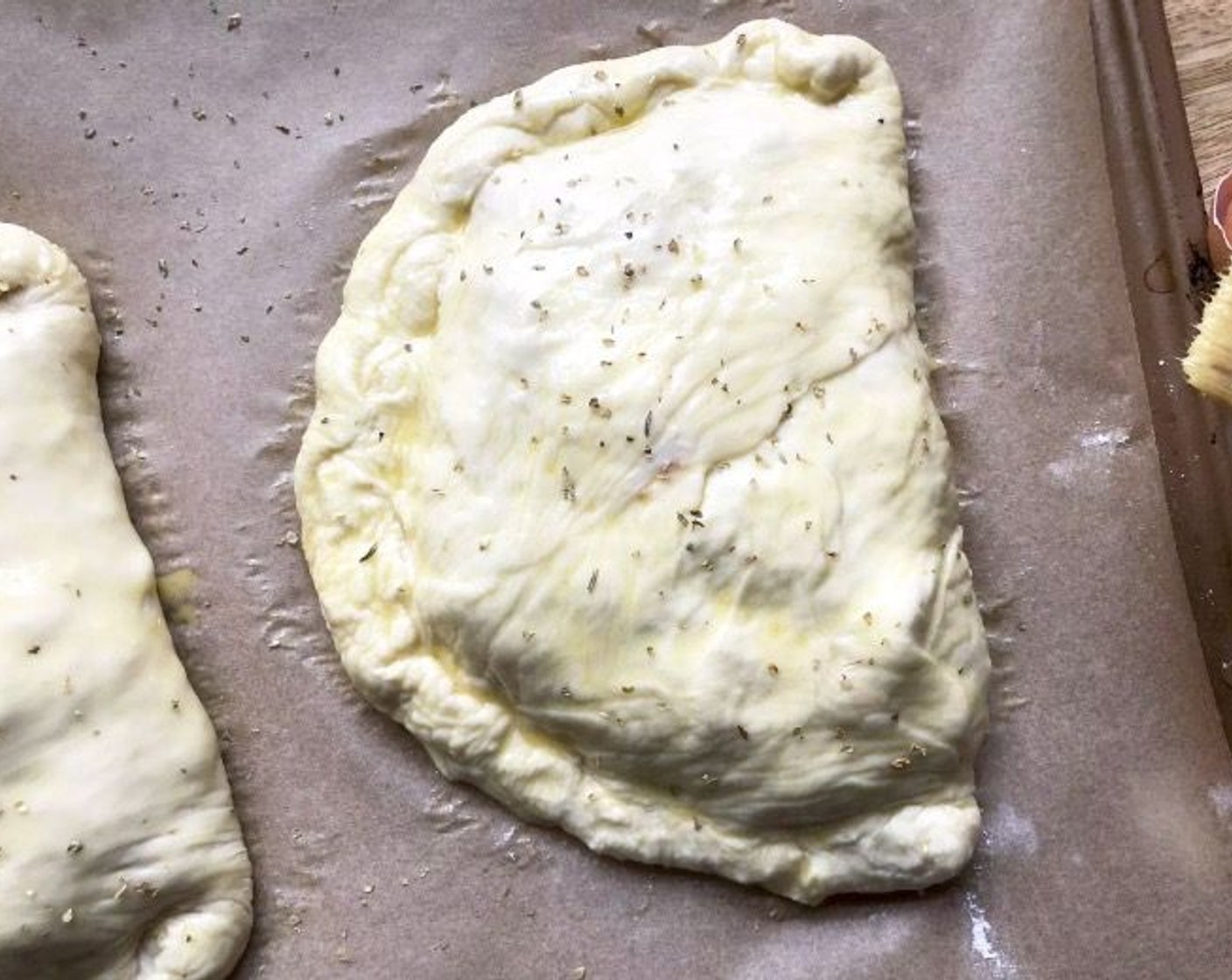step 6 Transfer the calzones to your prepared baking sheet, spacing at least 2 inches apart. Brush the tops with Egg (1) and apply a sprinkling of Italian Seasoning (1/2 tsp).