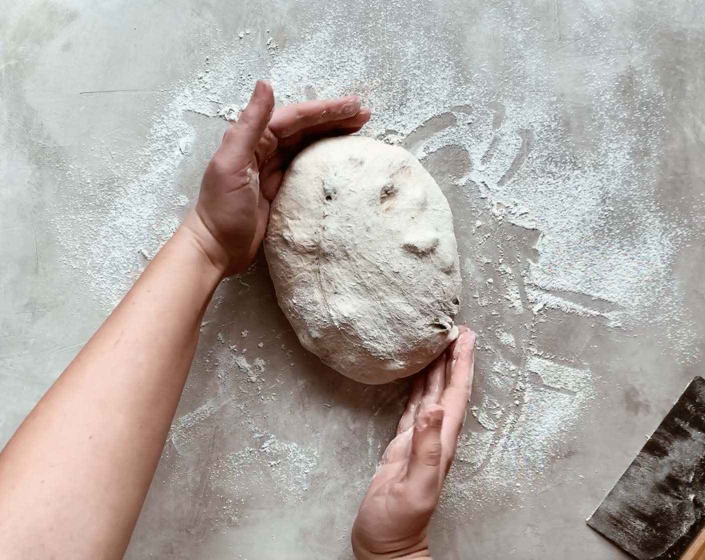 step 9 Flip the dough ball over, so the folds are facing down. Sprinkle the dough with a bit more flour, and gently shape the dough into a ball by rotating and pulling it towards you a few times. Do not knead the dough, just gently coax it until a round shape is formed.