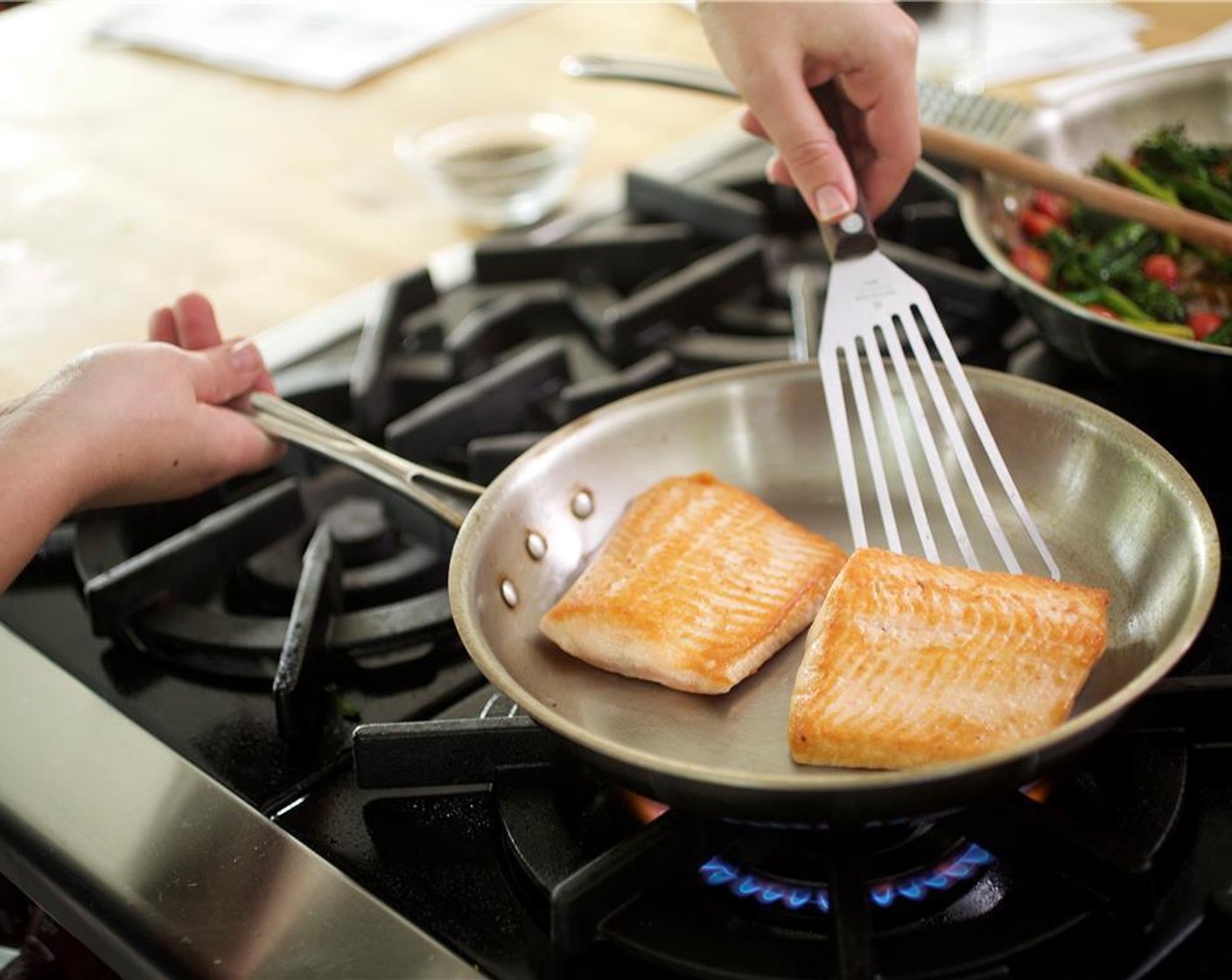 step 5 Pat the Arctic Char Fillets (2) dry with paper towels. Season the fish on both sides with Salt (1/4 tsp). Heat Canola Oil (2 Tbsp) in a large saute pan over medium high heat. When hot, add fish to the pan with the presentation side down. Cook for a minute and a half.