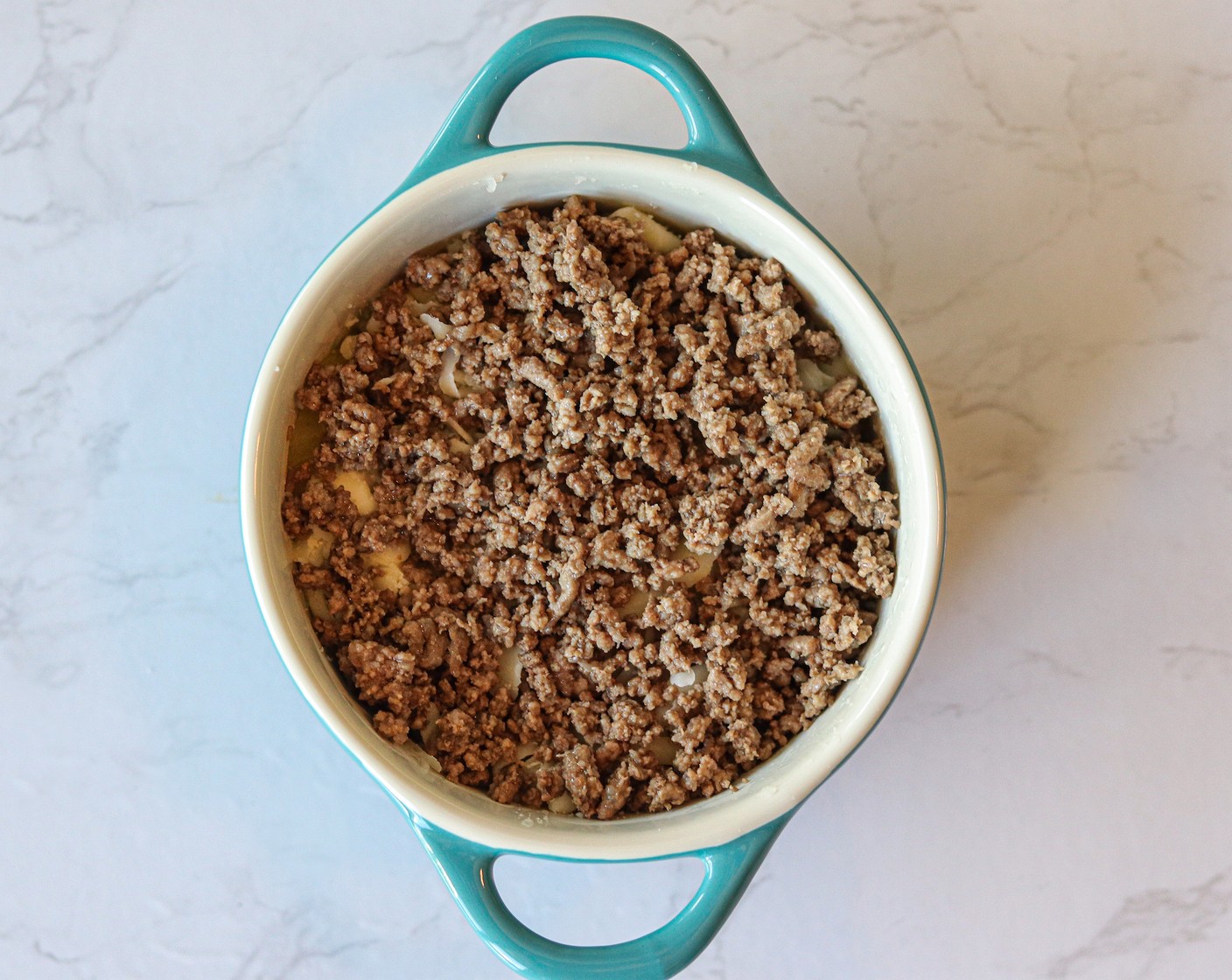 step 7 Top each casserole dish with a ¼ layer of ground beef. Then, top with the remaining potatoes.