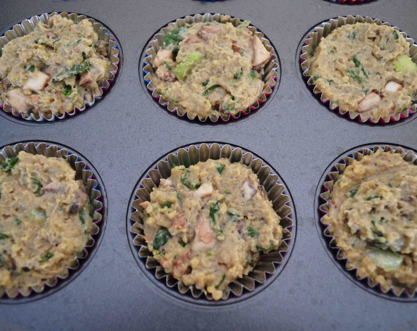 step 8 Scoop a 1/4 cup of batter into each well of the prepared muffin tin.