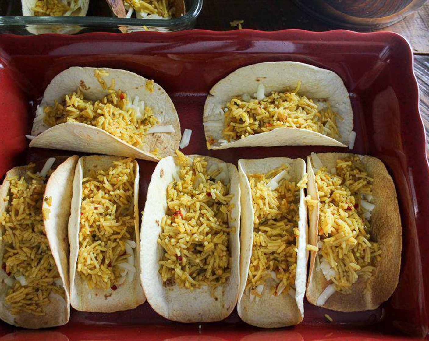 step 6 Place the prepared shells in the bottom of the baking dish. Sprinkle a little Monterey Jack Cheese (2 cups) into the bottom of each shell. Then evenly layer each shell with the Mexican Rice (1 pckg). Top evenly with the cheese and meat mixture. Finish by topping each taco with the remaining cheese.