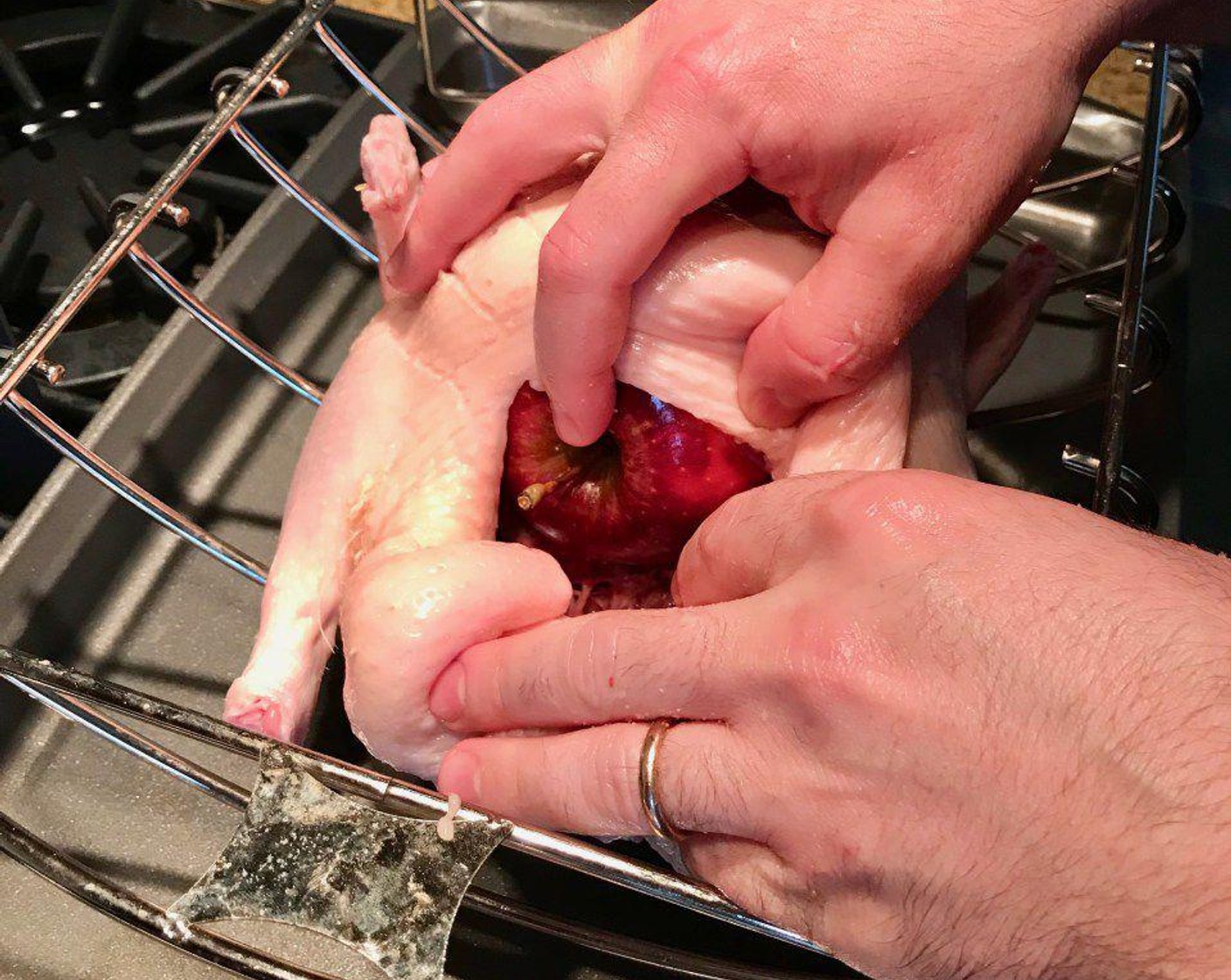 step 5 Fold the neck skin under the body, then place the duck, breast side up, on a roasting rack in a roasting pan. Place an Apple (1) inside the cavity.