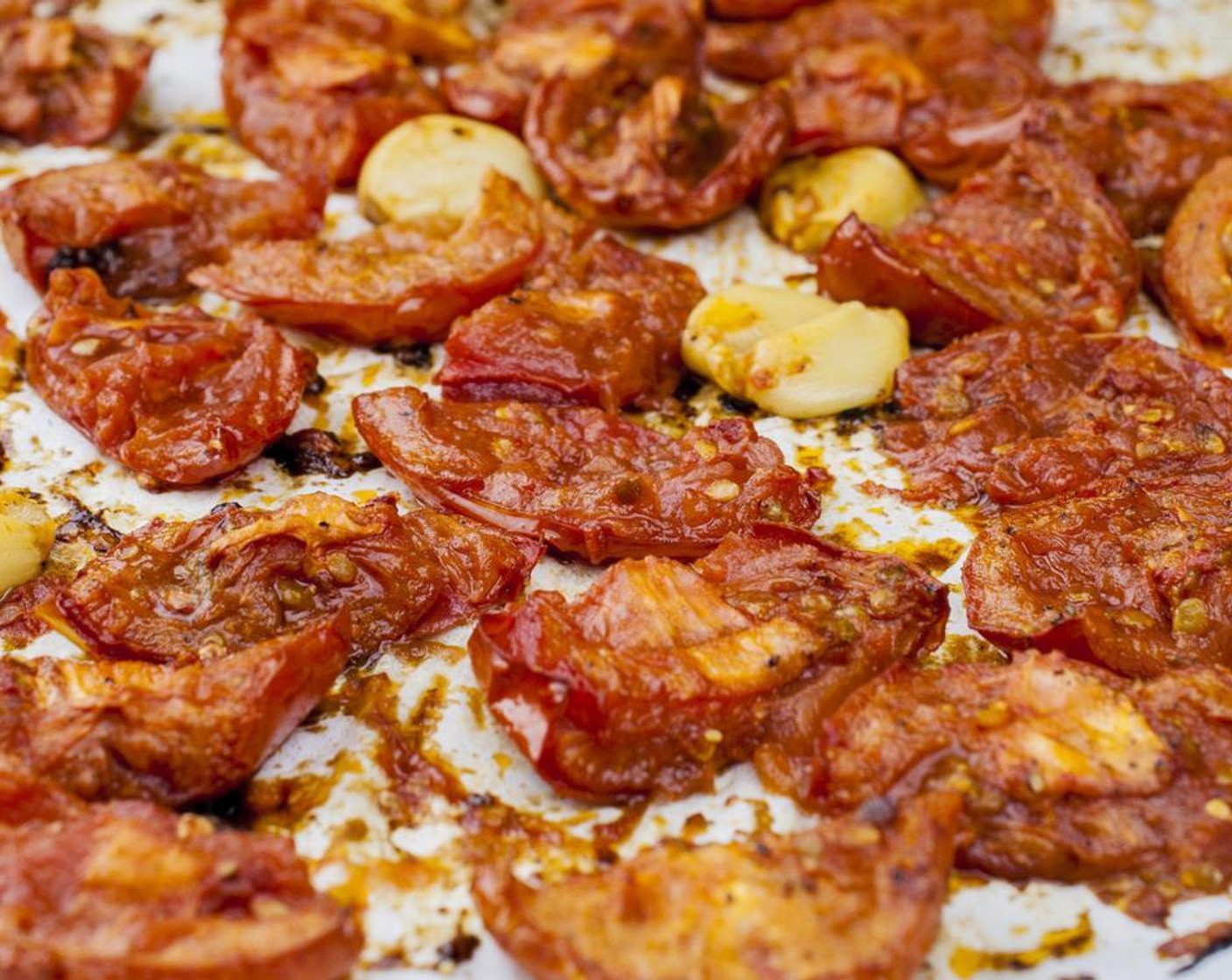 step 4 Arrange tomatoes skin side down and garlic in a single layer on a parchment lined sheet pan with edges. Roast for 1 1/2 hours. Remove from oven an allow to cool on pan.