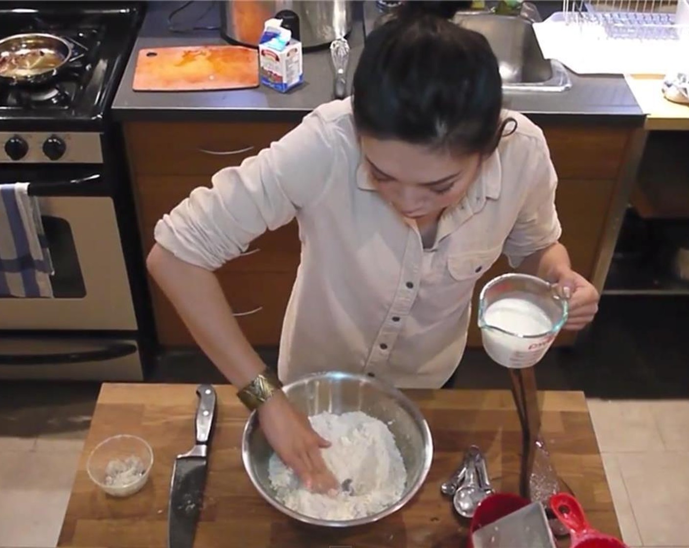 step 7 Make a well in the middle of the flour and add 2% Reduced Fat Milk (1 cup). Add a little at a time and gently fold in the flour until all the milk is inside. Start mixing with your hands just until everything is evenly incorporated.