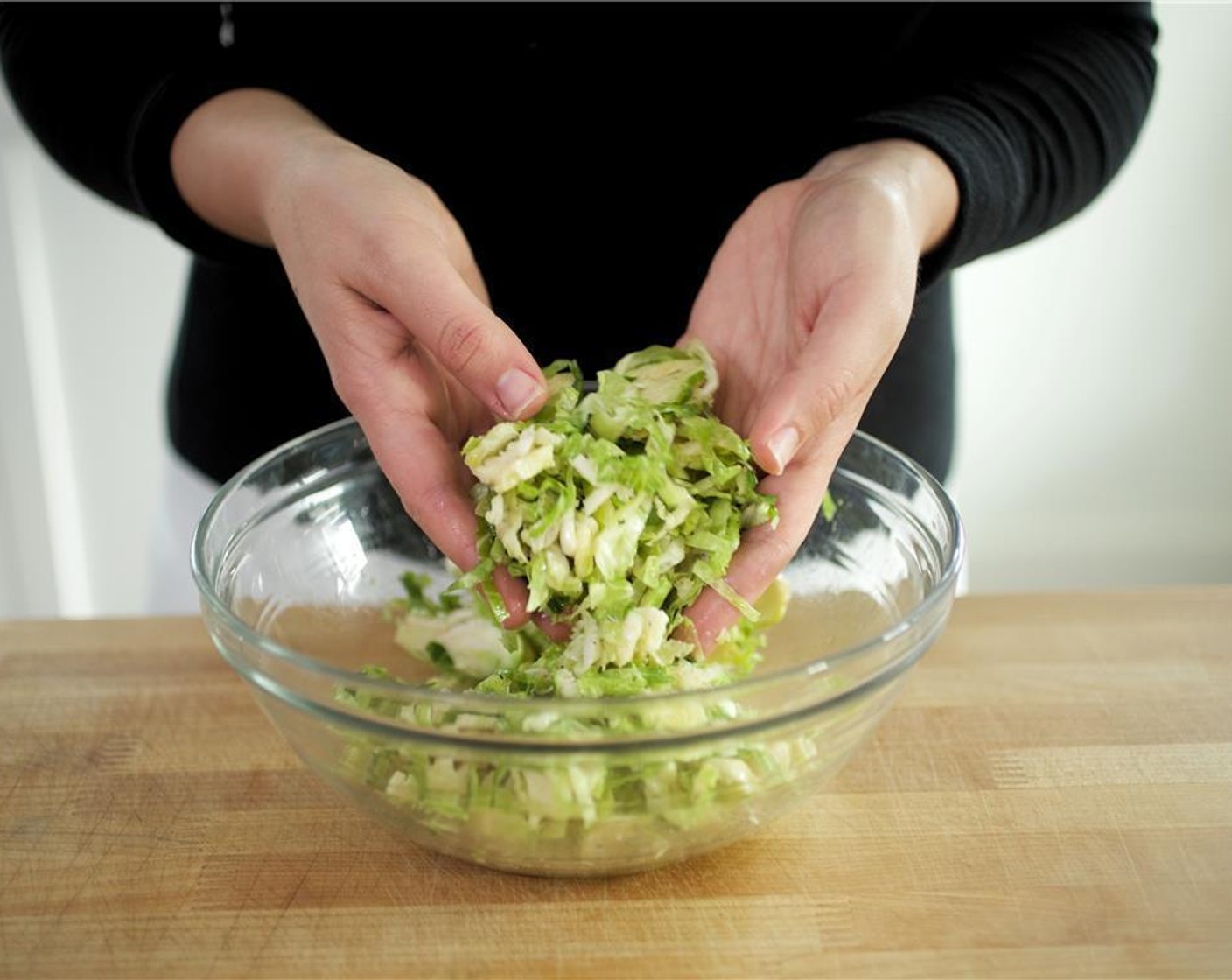 step 5 Meanwhile, cut Brussels Sprouts (2 1/2 cups) in half, then slice into quarter inch shreds with the flat side down. Place the sprouts in a medium bowl with Olive Oil (1 Tbsp), Salt (1/4 tsp), and Ground Black Pepper (1/4 tsp).