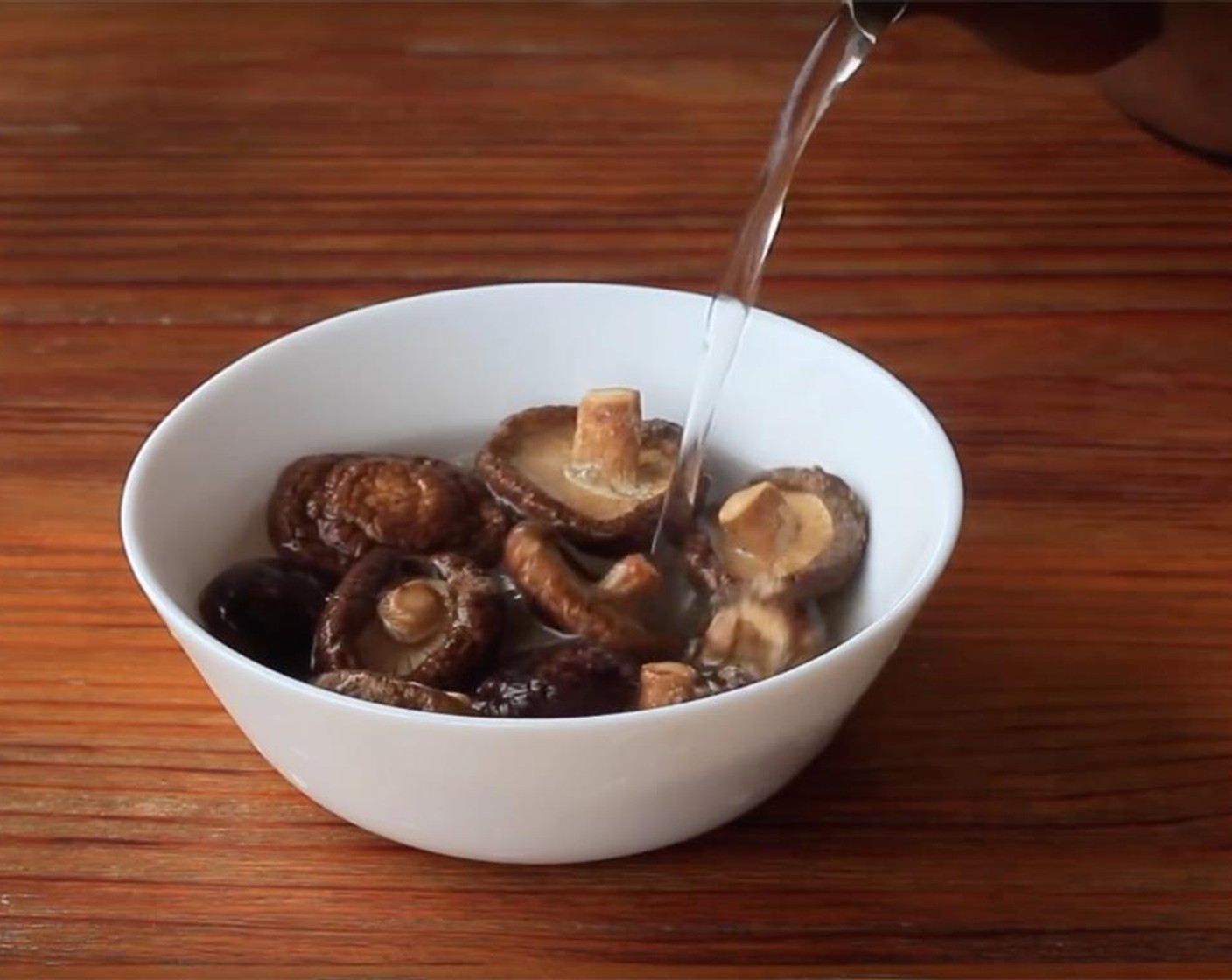 step 3 Soak the Dried Shiitake Mushrooms (8) with hot water for 2-3 minutes. Transfer the shiitake mushroom out and re-soak with hot water. Discard the first soaking water and strain the second soaking water for later filling.