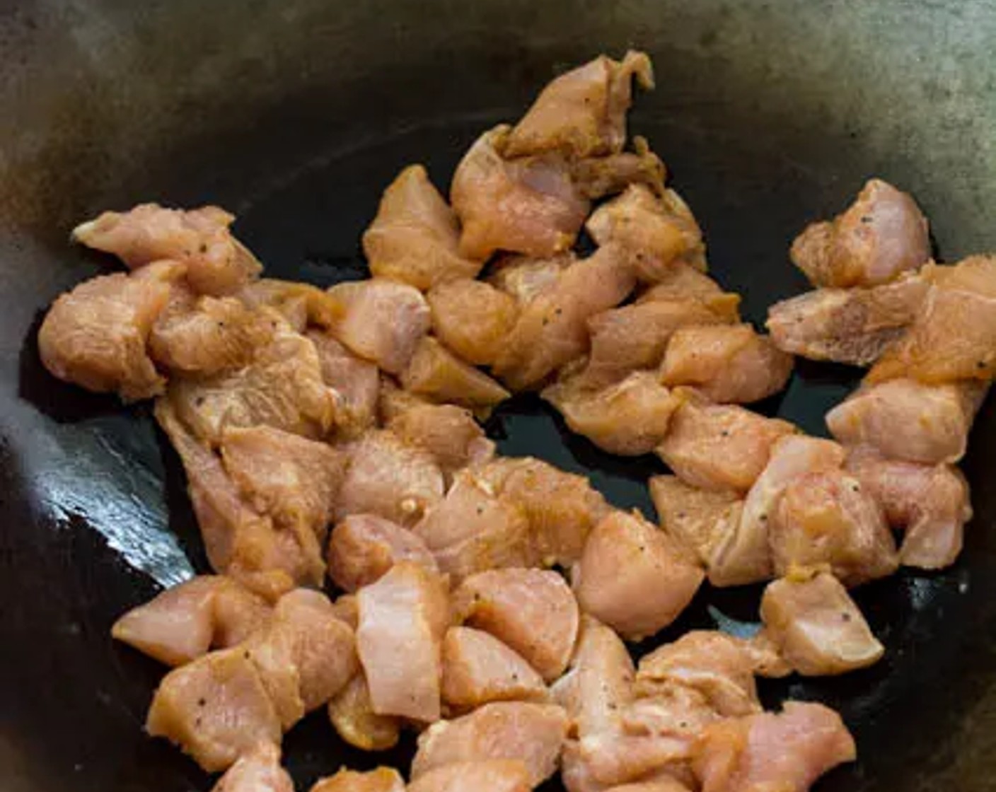 step 4 Add the remaining Cooking Oil (2 Tbsp) if the wok is too dry, add the marinated chicken in a single layer. Stir-fry in two batches if needed (don't overcrowd the wok).