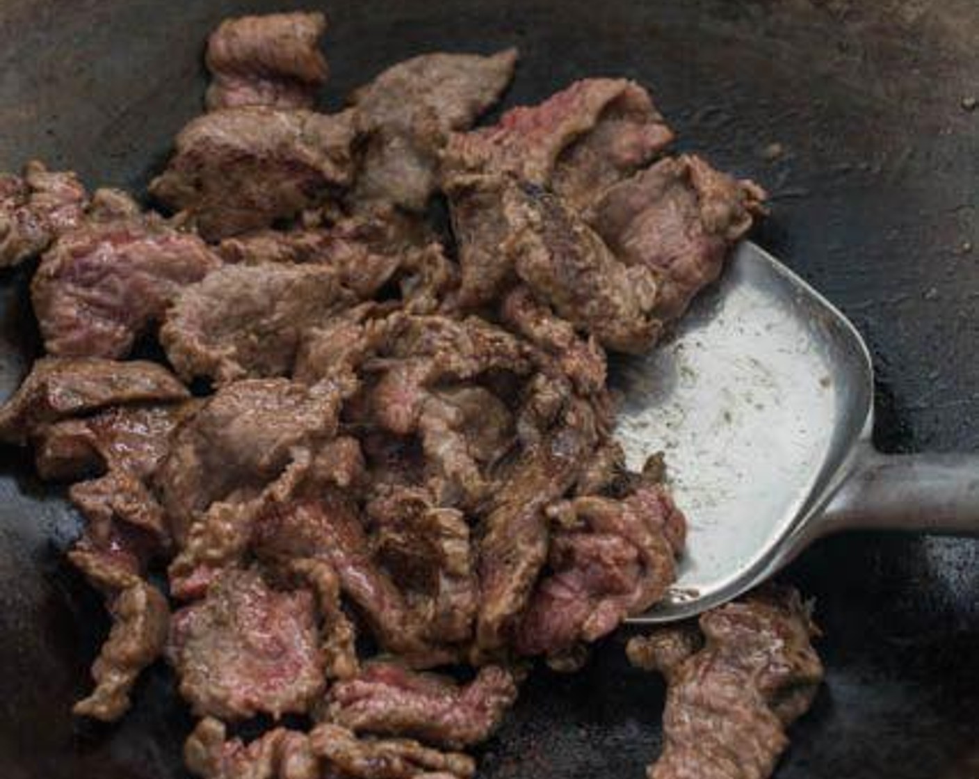 step 4 Heat up Cooking Oil (2 Tbsp) in a wok over medium-high heat. When the wok starts to smoke just slightly, add the beef to the wok in a single layer. Leave the beef untouched for about 15 seconds to allow it to sear before flipping it with your wok spatula. Stir-fry the beef just until it is no longer pink, then remove the beef from the wok.