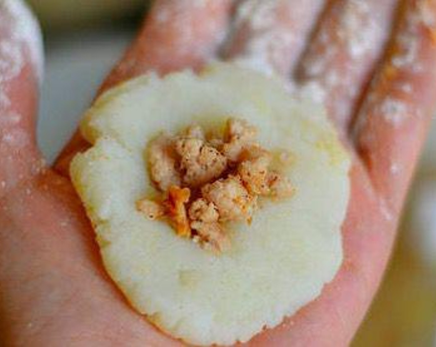 step 6 Dust your hands with flour and make a golf-sized ball of mashed potato mixture. Flatten it into a circle and put a small amount of turkey in the middle. Don’t overfill. Carefully close it into a ball by pinching edges together.