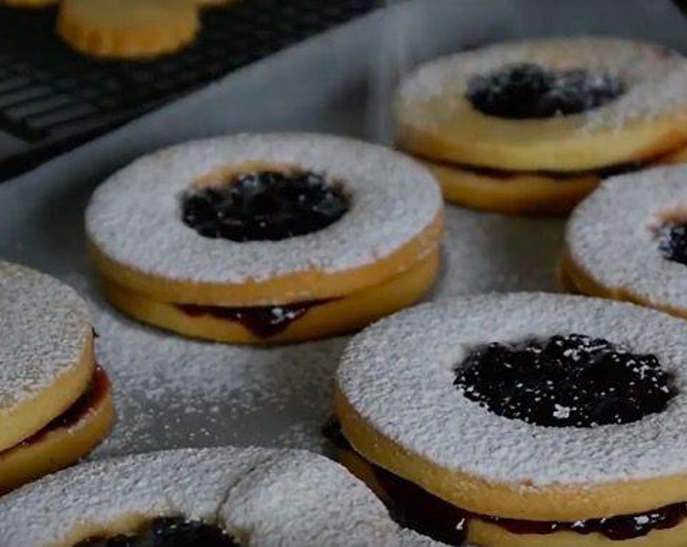 step 8 To fill them take one of the “blind” circles and add about 1 tsp of Cherry Jam (as needed), then place one of the “open” halves on top and press carefully to set both biscuits. Top with Powdered Confectioners Sugar (to taste).