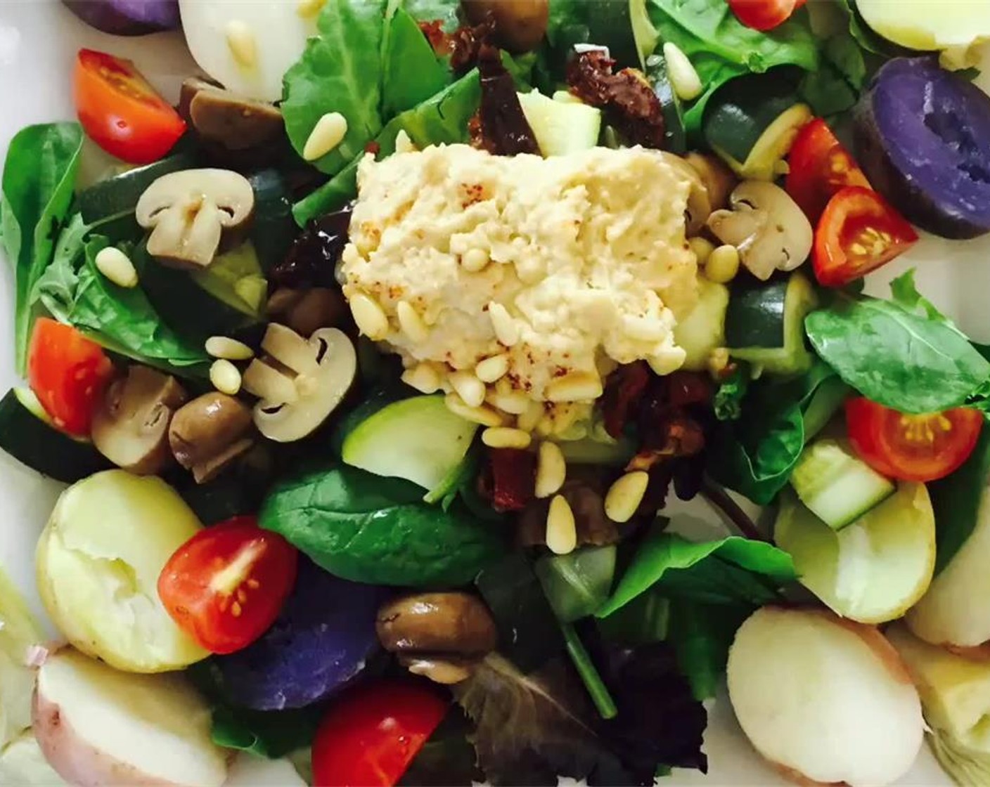 step 3 Top with the baby potatoes, zucchini, cherry tomatoes, artichoke, canned mushrooms, sun-dried tomato, Pine Nuts (to taste), and a scoop of Hummus (to taste). Serve and enjoy!