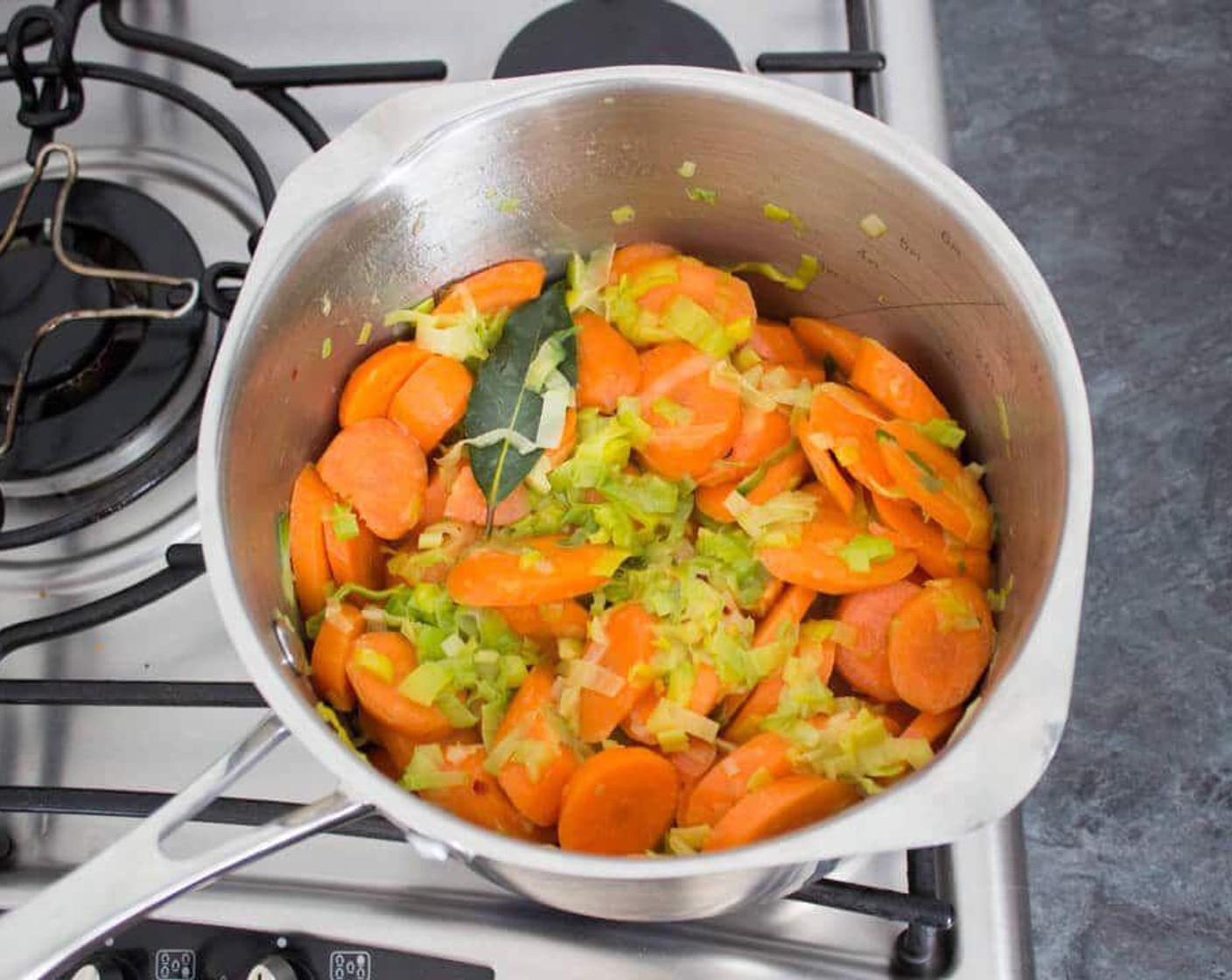 step 2 Add Carrots (5 2/3 cups), Honey (1 Tbsp), Aleppo Chili Flakes (1 pinch), Bay Leaves (2) and Salt (1 pinch) and stir. Allow to cook for a couple of minutes, stirring often.