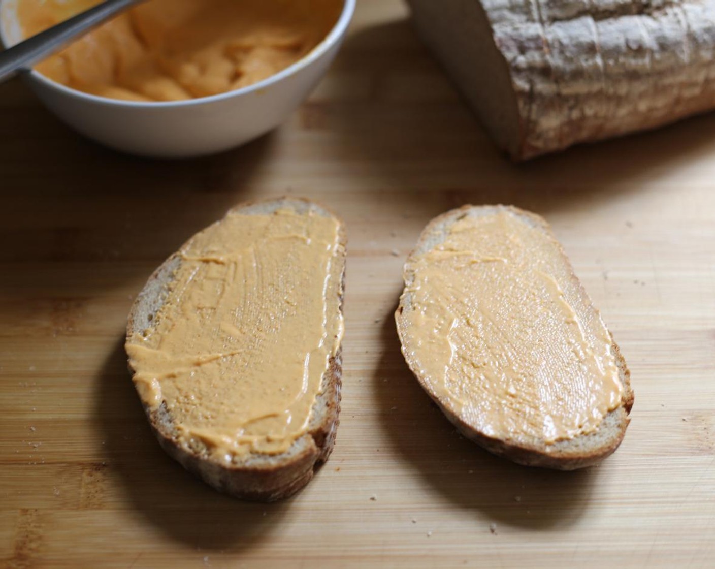 step 8 Spread two slices of the Sourdough Bread (8 slices) with additional Gochujang Aioli and heat up a skillet over medium heat.