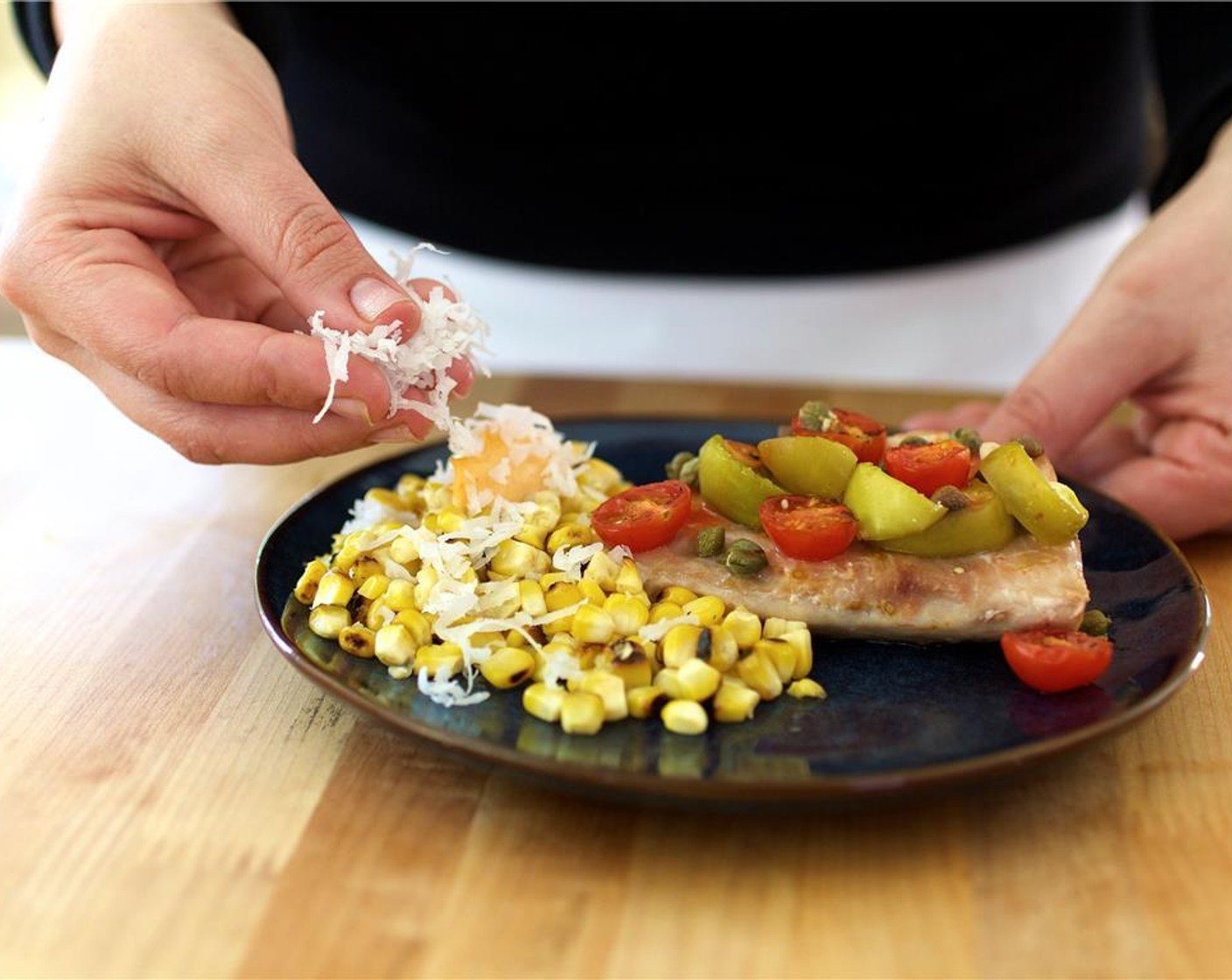 step 11 Place the fish in the center of two plates. Top with tomatillo and tomato mixture. Place the corn and top with sriracha mayonnaise and Unsweetened Coconut Flakes (2 Tbsp).