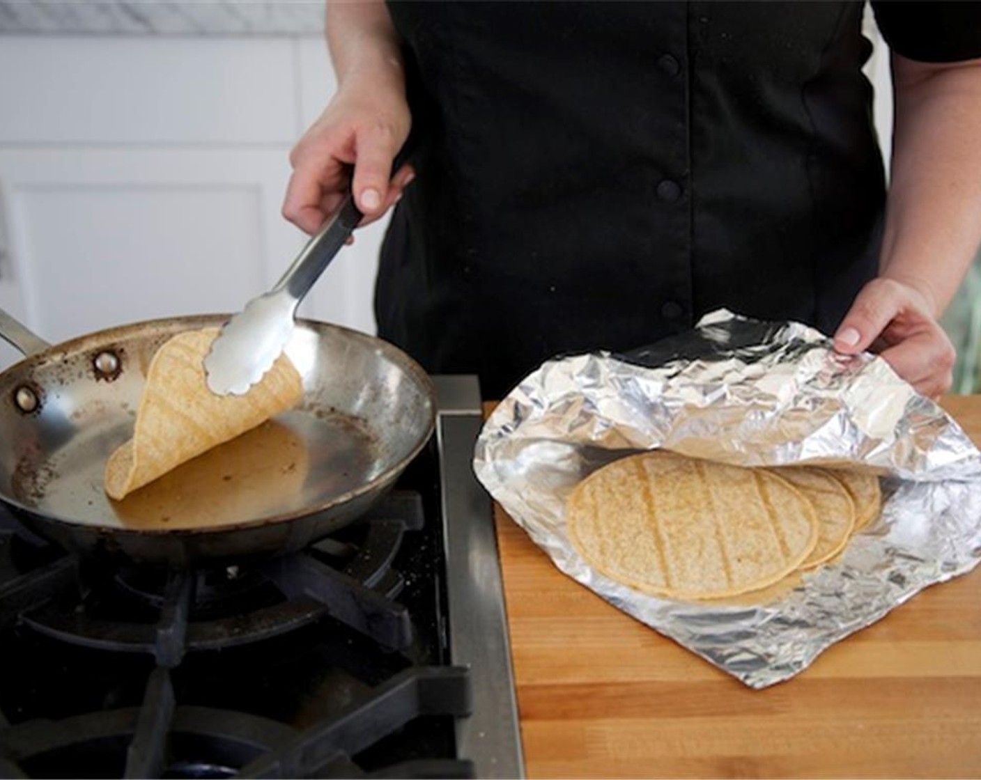 step 7 Heat a medium saute pan over high heat. Add the White Corn Tortillas (4) one at a time. Cook on both sides for thirty seconds per side until very hot. Wrap in foil and set aside for plating.