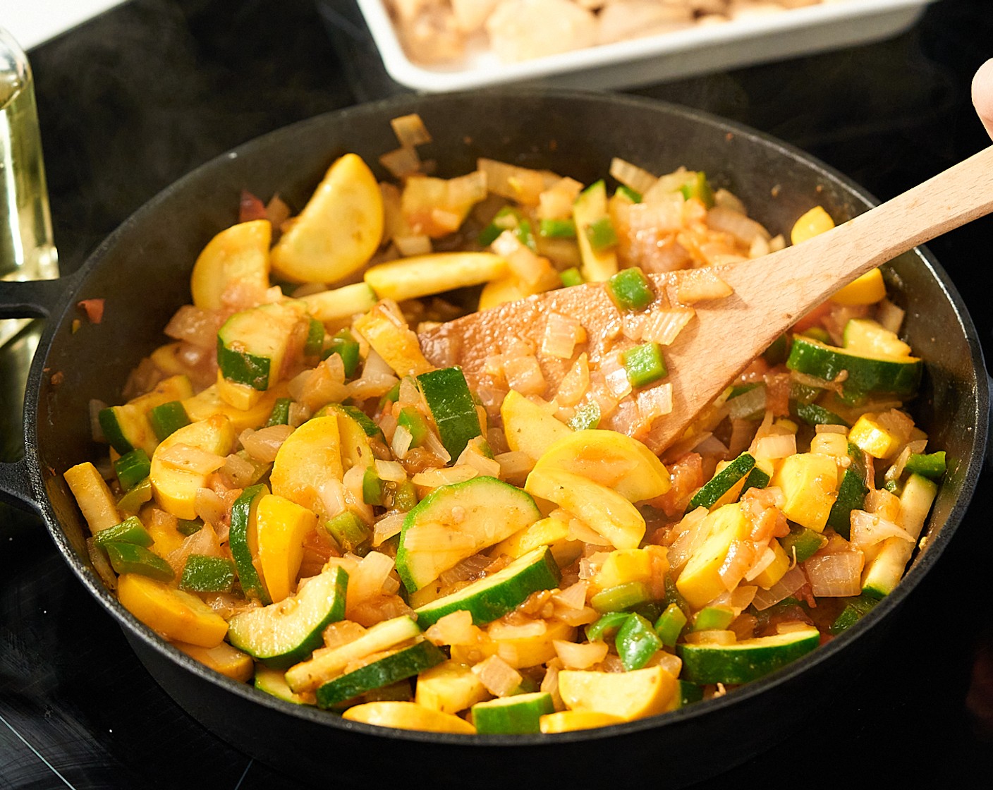 step 4 In der gleichen Pfanne das übrige Pflanzenöl (1 EL) erhitzen. Zucchini (1), Kürbis, gelb (1), Tomate (1), Zwiebel, weiß (1) und Paprika, grün (1) hinzugeben. Mit Kreuzkümmel, gemahlen (1/2 TL), Mexikanischer Oregano (1/2 TL) und Ancho Chilipulver (1/2 TL) würzen und für 5 Minuten, andünsten, bis das Gemüse leicht gar ist.