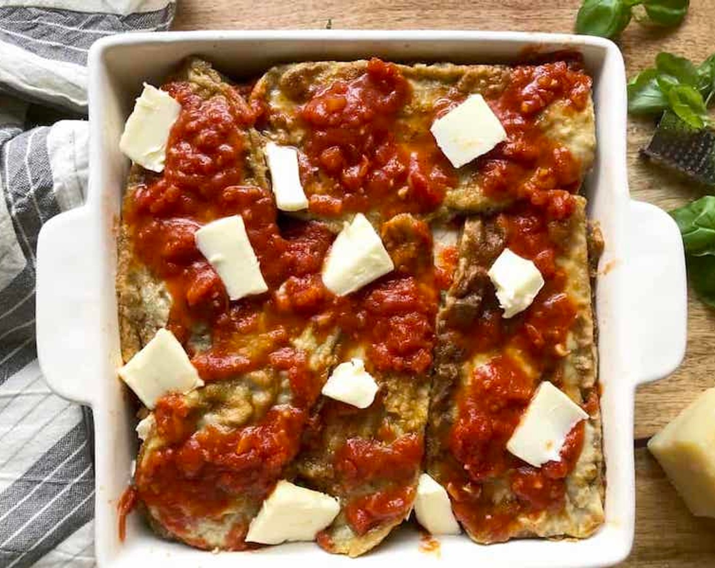 step 12 Proceed with two more coated layers of eggplant slices. Finish up with one last layer of eggplant topped off with a slightly more generous layer of marinara sauce. Dot the top with evenly placed bits of Butter (2 Tbsp).