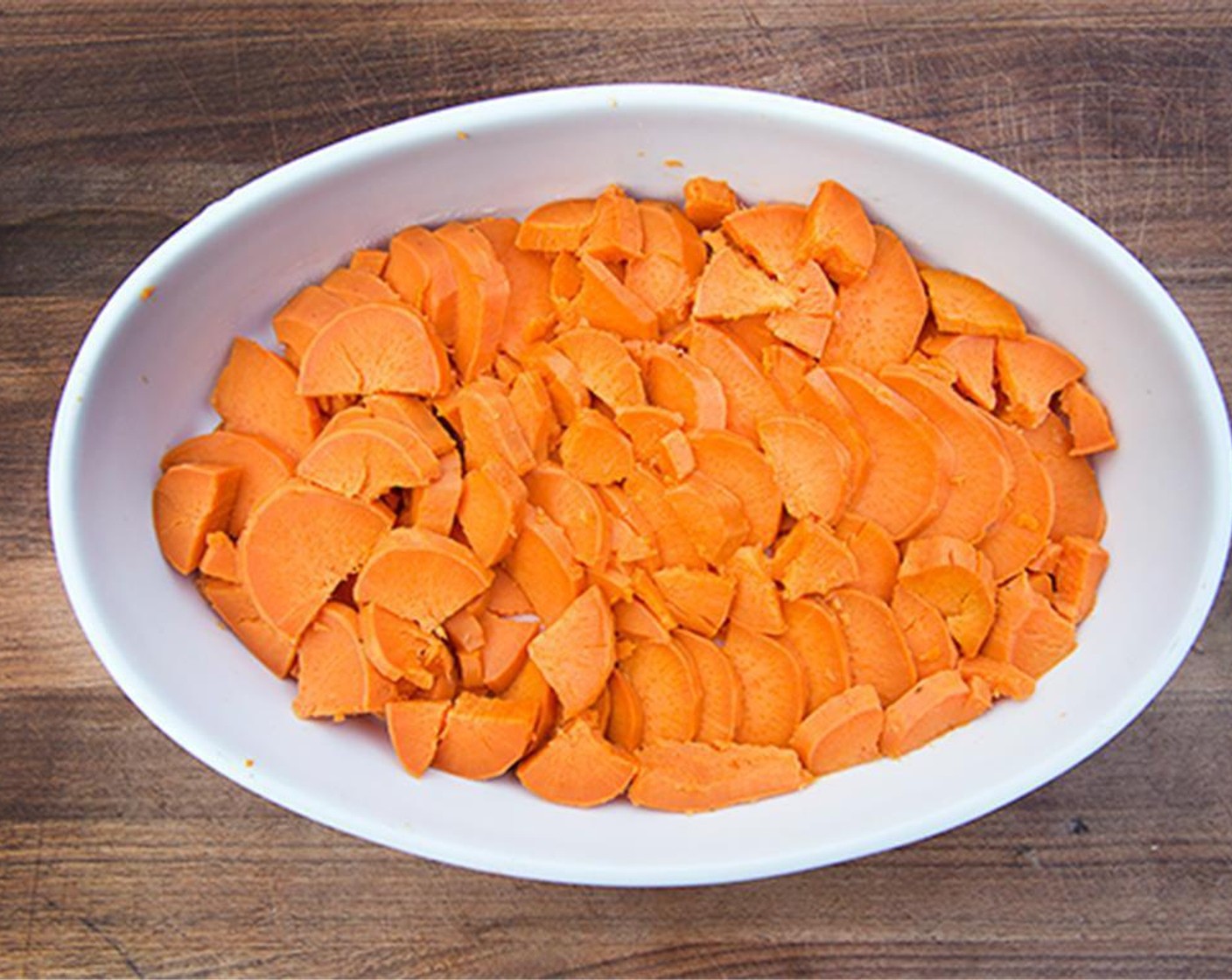step 3 Drain, cool and cut the sweet potatoes into quarter-inch slices. Lightly grease another 8 x 11-inch baking dish.