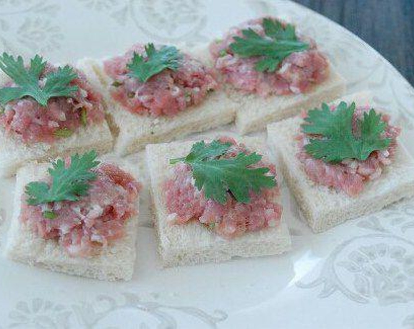 step 2 Cut a slice of Bread (4 slices) into 4 pieces, spread minced pork on the bread and place one piece of Fresh Cilantro (to taste).