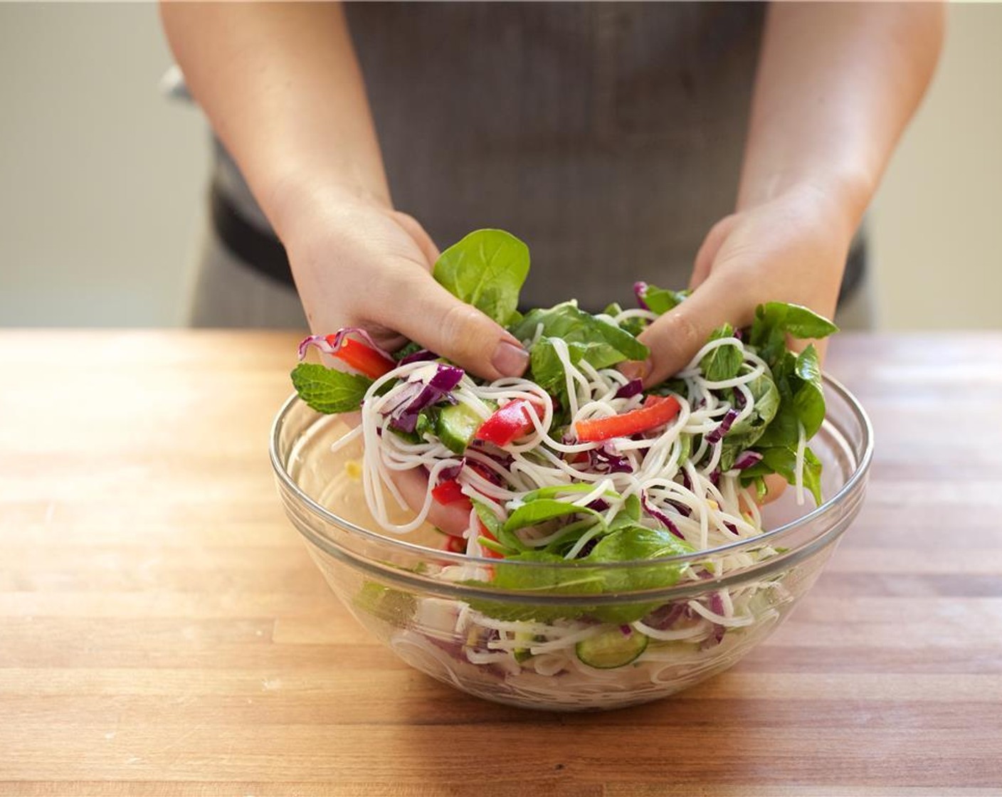 step 8 In the bowl with the noodles, add Arugula (2 3/4 cups), Red Cabbage (2/3 cup), Basil, Cilantro, Mint, Red Pepper, mini cucumber, and remaining dressing. Toss to combine.