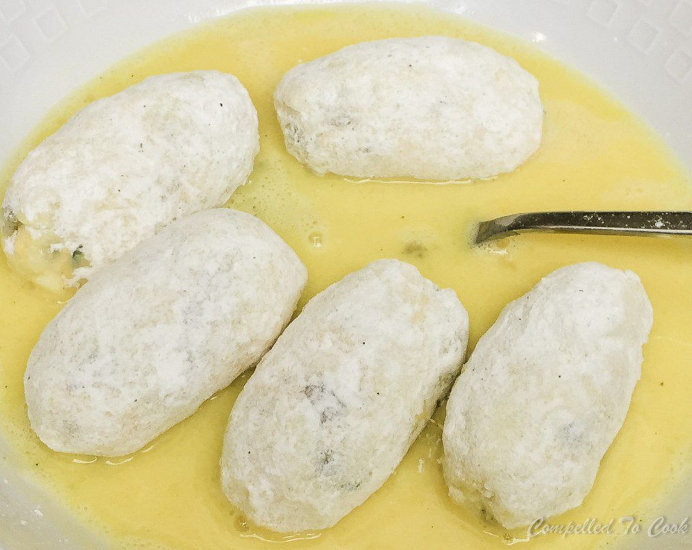 step 9 Scoop out of egg wash and roll in breadcrumbs, pressing gently to adhere and coat completely. Set aside on a tray and repeat with remaining croquettes.