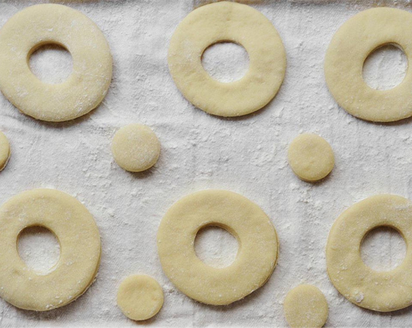 step 8 Cut out doughnuts with a doughnut or cookie cutter. Place the doughnuts on the prepared pans, spacing them out evenly. Cover with plastic wrap and place in a warm spot.