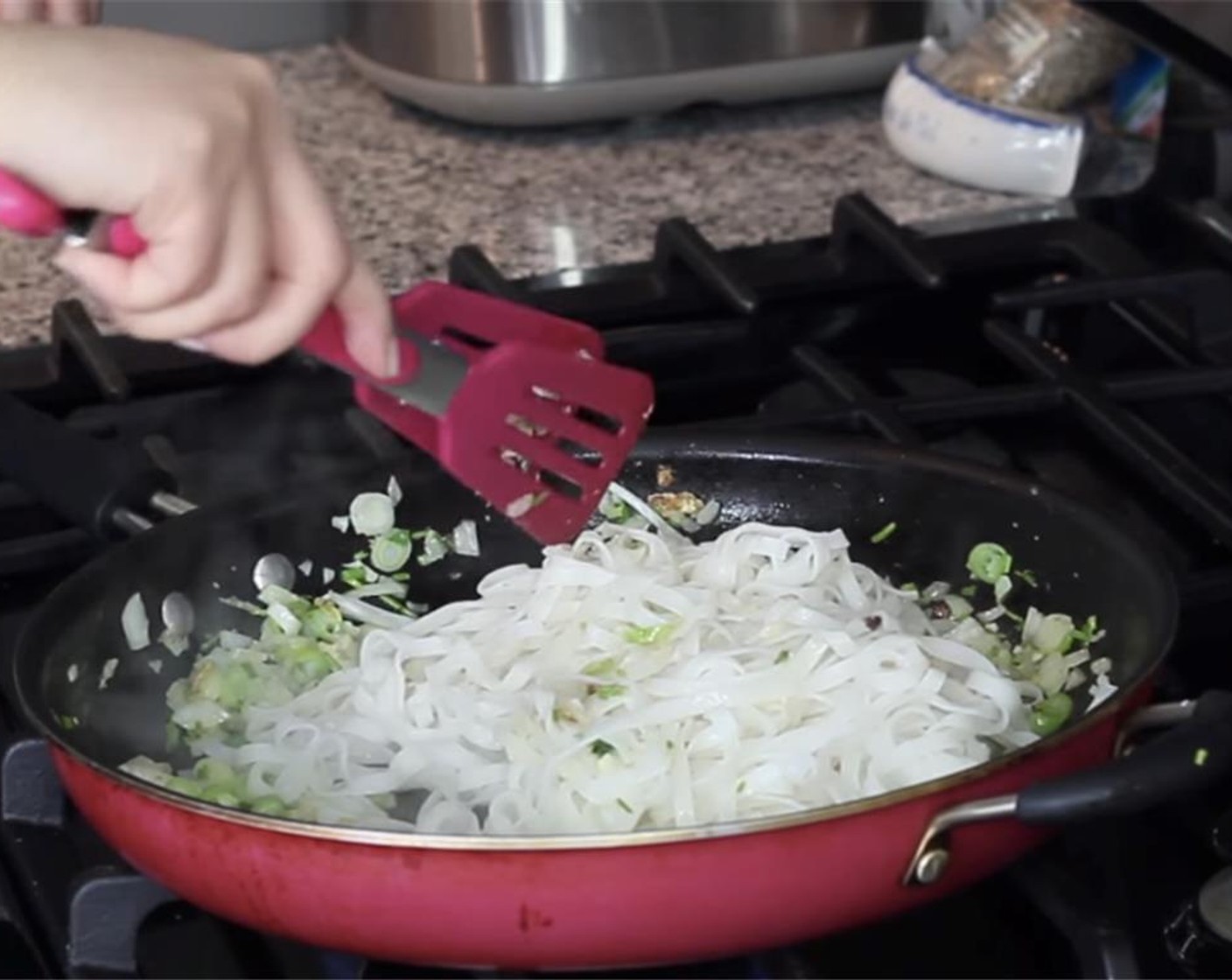 step 14 Add the partially-cooked noodles. Using tongs, loosen the cold noodles. Toss and let it absorb the fragrant oil.