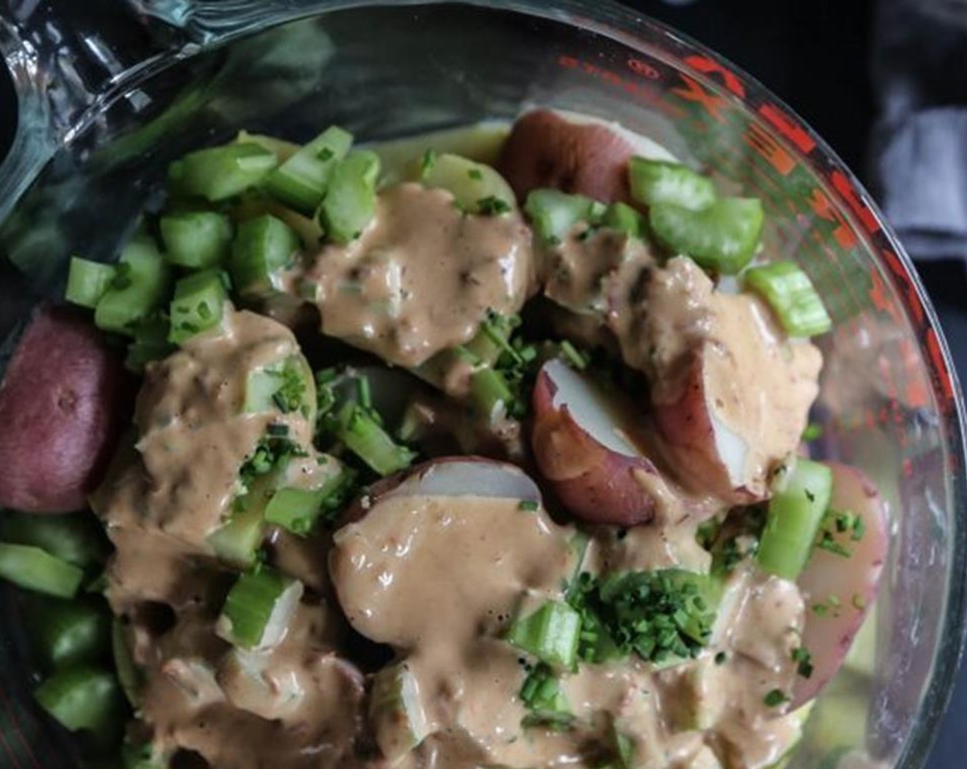 step 7 Next, halve the cooled potatoes and place into a large serving bowl. Add the Celery (3/4 cup), Red Onion (1/4 cup), Fresh Parsley (2 Tbsp), and mayo mixture. Toss to combine adding Salt (to taste) and Ground Black Pepper (to taste).