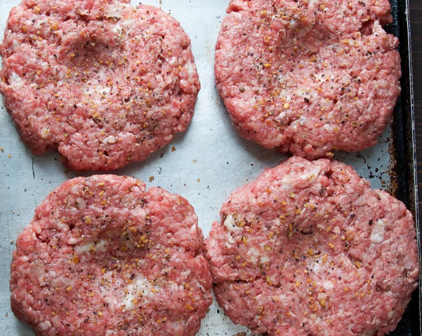 step 4 Form the beef into four 4" patties about 1/3-1/2" thick. Use your thumb or the back of a spoon to form a depression in the center of each patty.