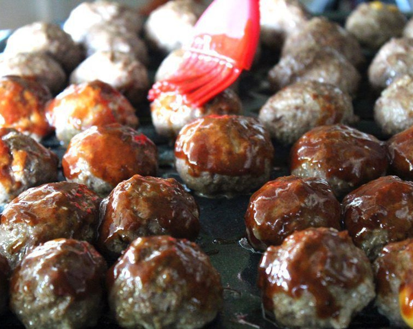 step 8 Place the meat balls onto the prepared broiler pan. Use the kind with a drip pan so the grease drips into a catch pan. Bake for 10 minutes. Remove and baste on all sides with the remaining Barbecue Sauce (1/4 cup).