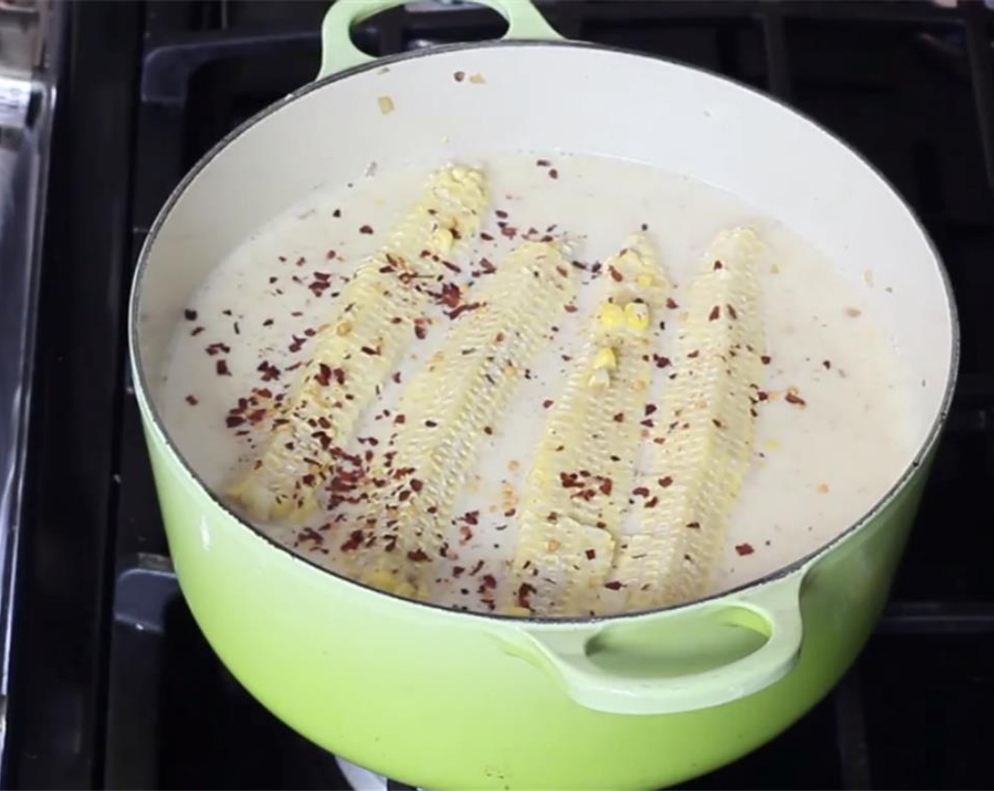 step 8 Add whole Milk (4 cups), Chicken Stock (2 cups), saved corn cobs, and Crushed Red Pepper Flakes (1/2 tsp). Add some Salt (to taste) and Ground Black Pepper (to taste) and mix.