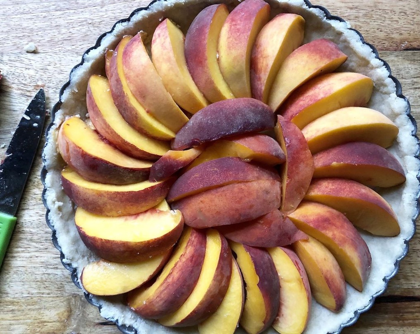 step 6 Starting on the outside, arrange the Peaches (3) slices overlapping in a concentric circle over the pastry; fill in the center in whatever pattern makes sense. The peaches should fit snugly.